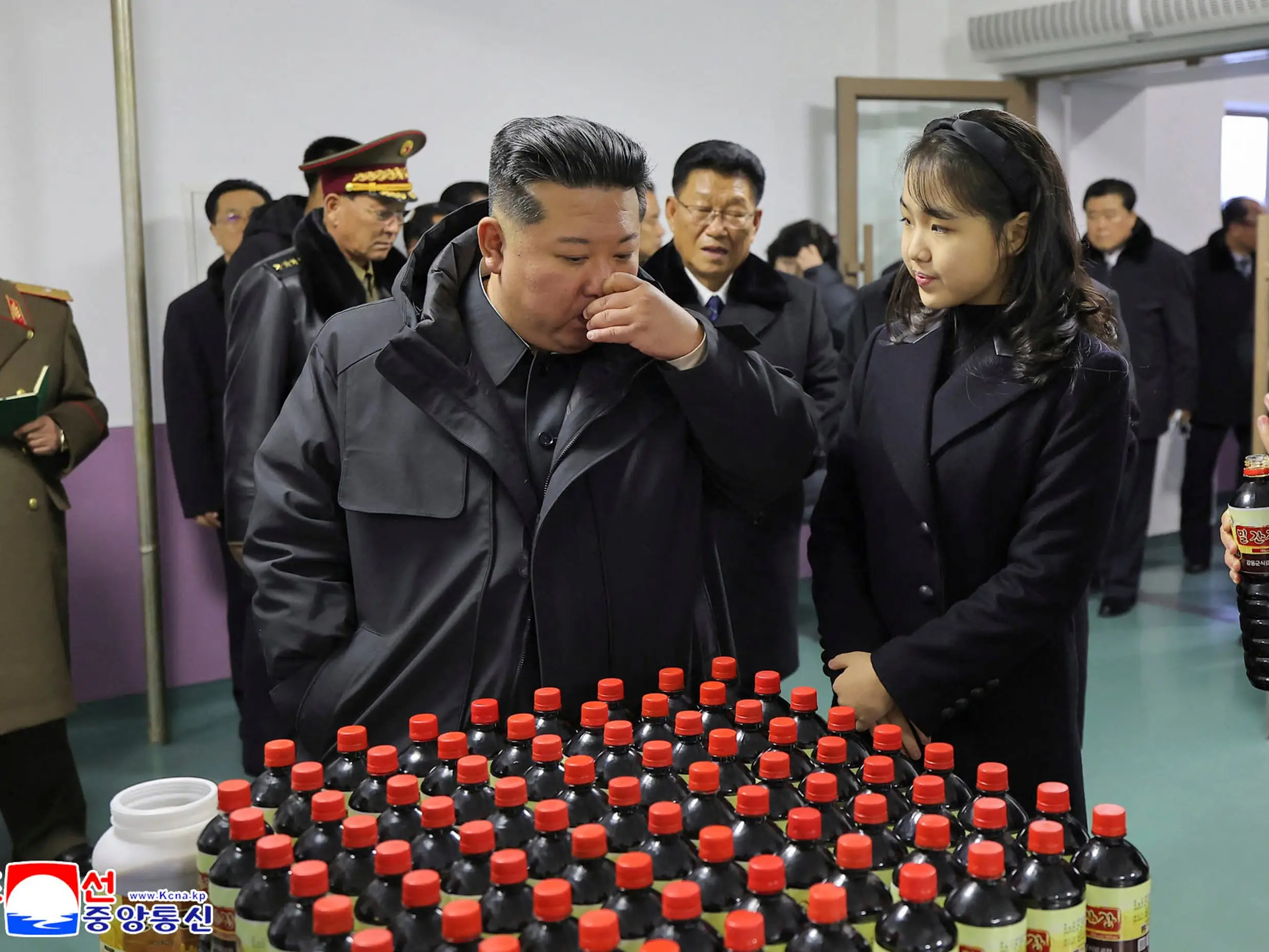 Kim Jong Un looks at soft drinks at a food factory with his daughter, Ju Ae.