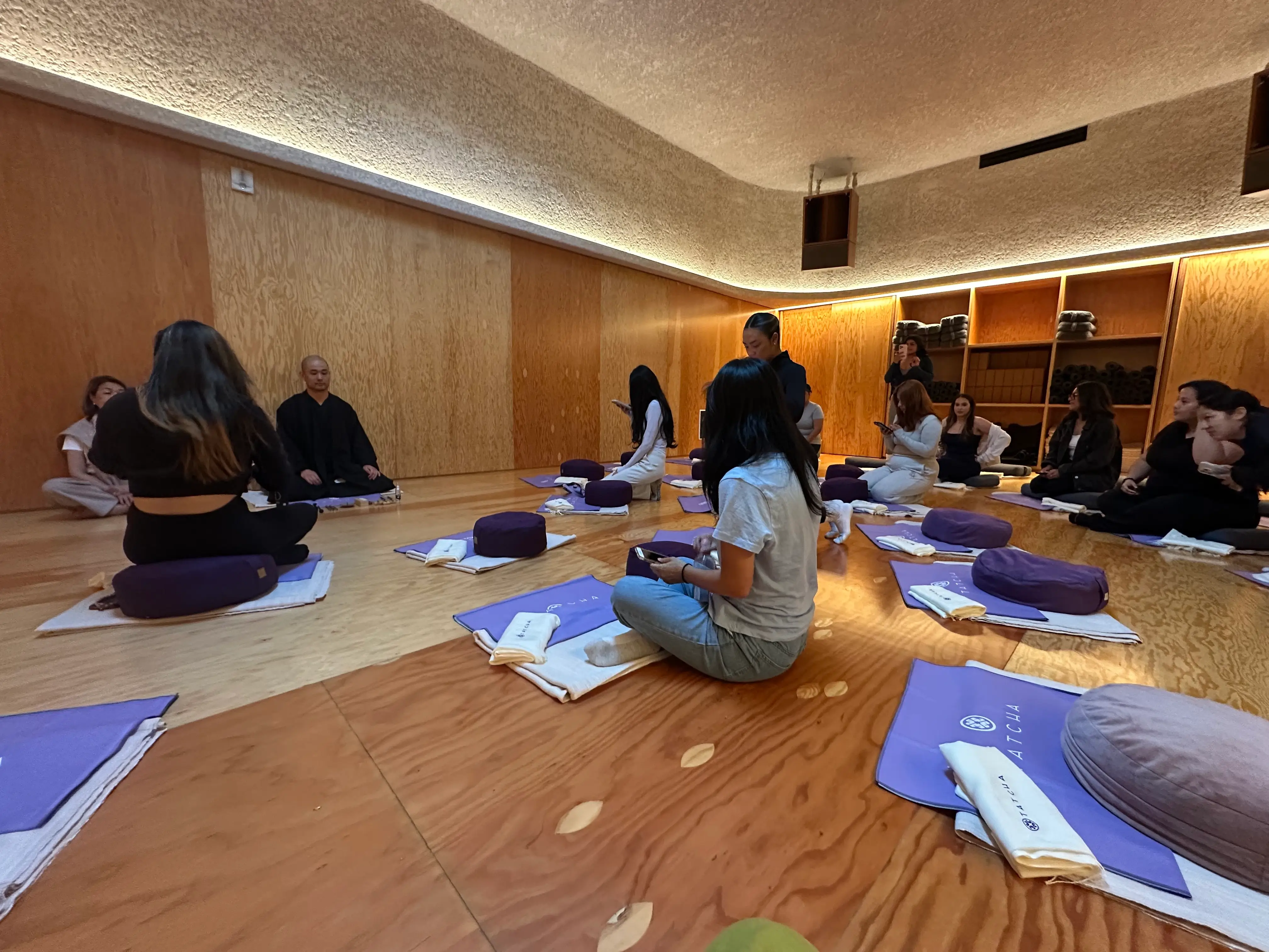 Toryo Ito seated at the front of a meditation studio fill of guests.