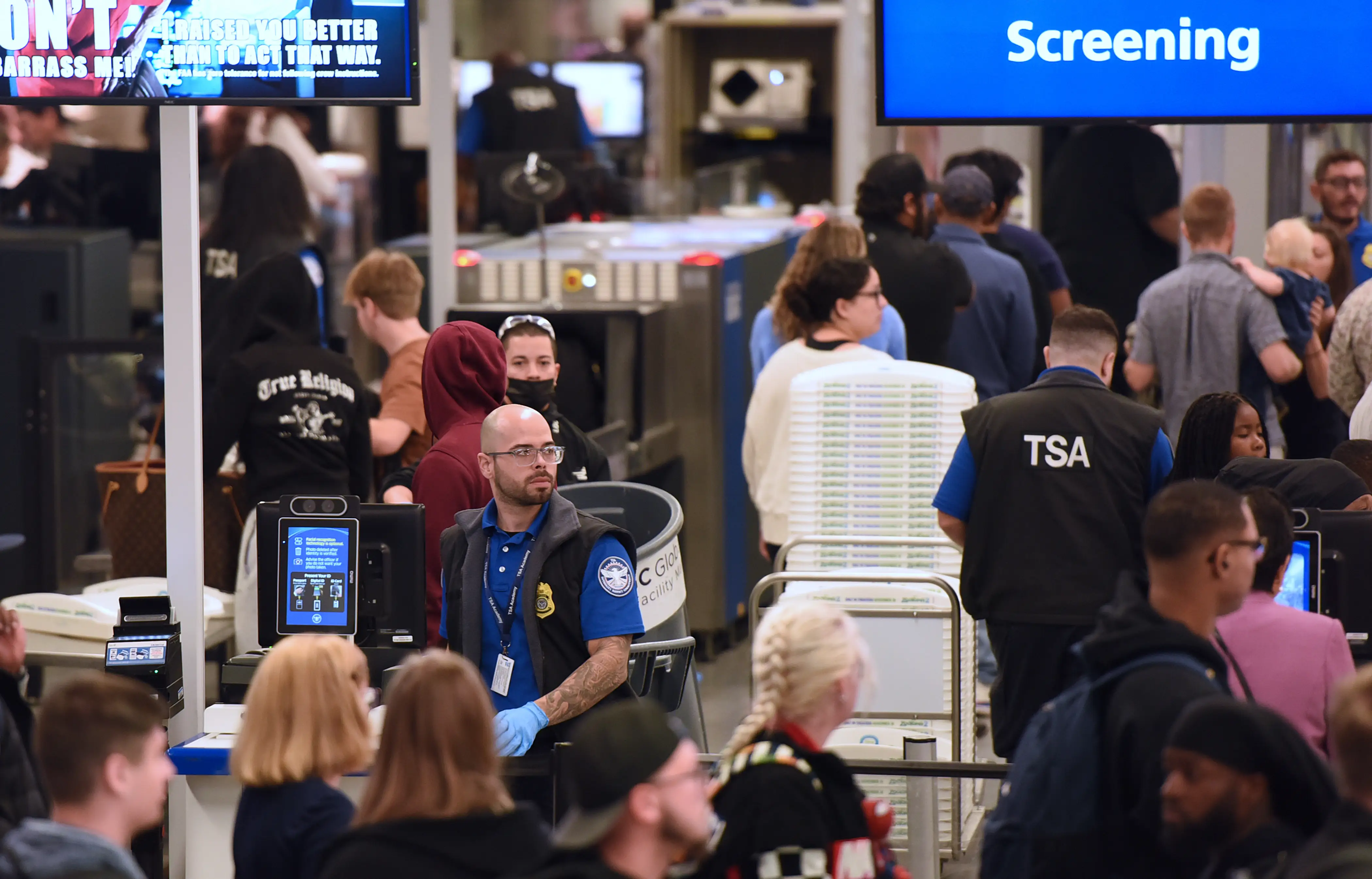 Travelers move through a TSA security screening line at Orlando International Airport on the day before Thanksgiving in Orlando, Florida, United States, on November 26, 2025.