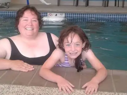 A mom and her child at a swimming pool.