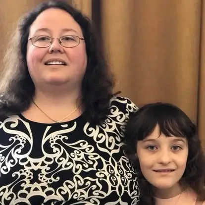 A woman wearing a black and white top and her daughter