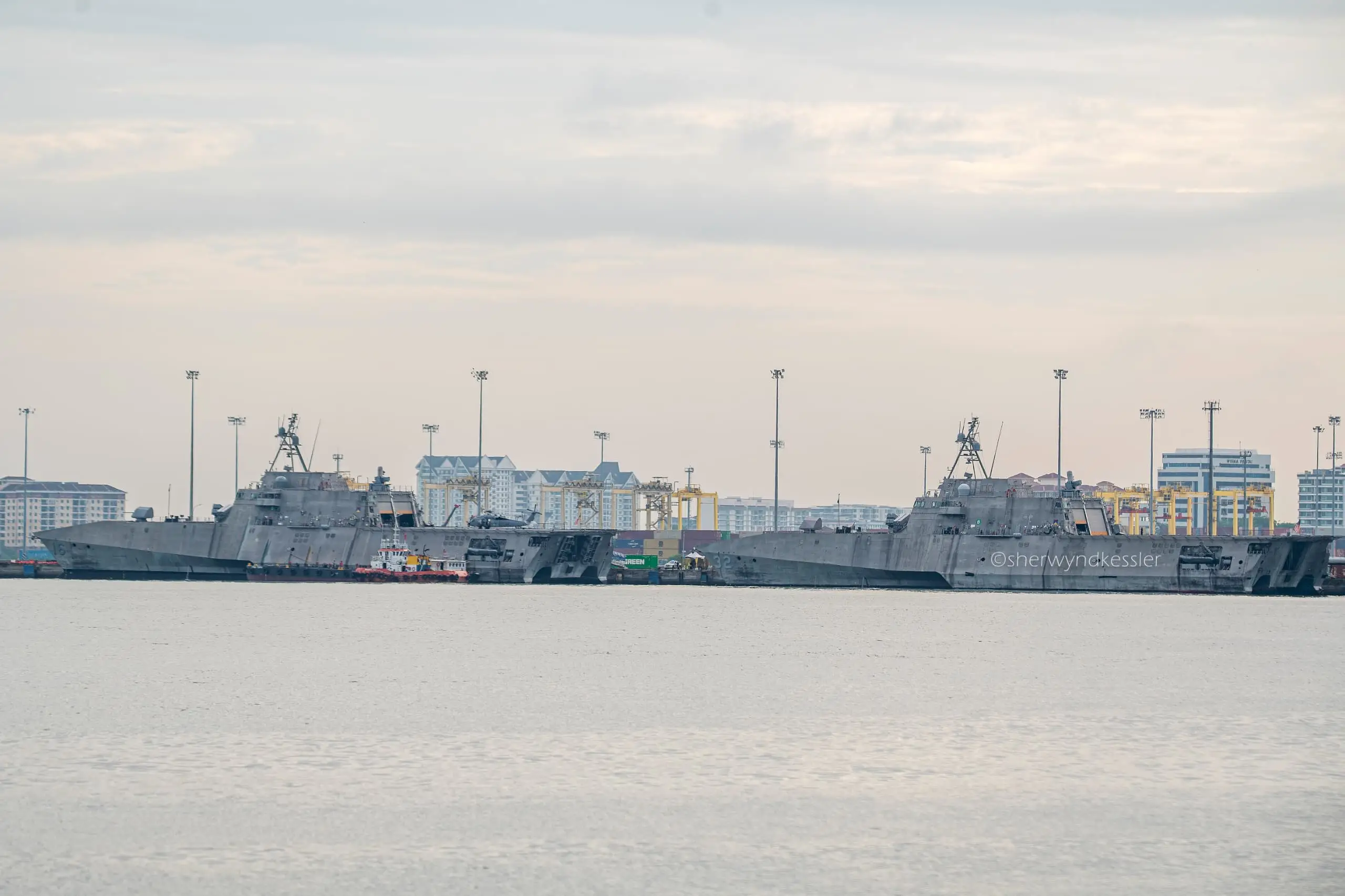 Two US warships can be seen in front of the Butterworth skyline.