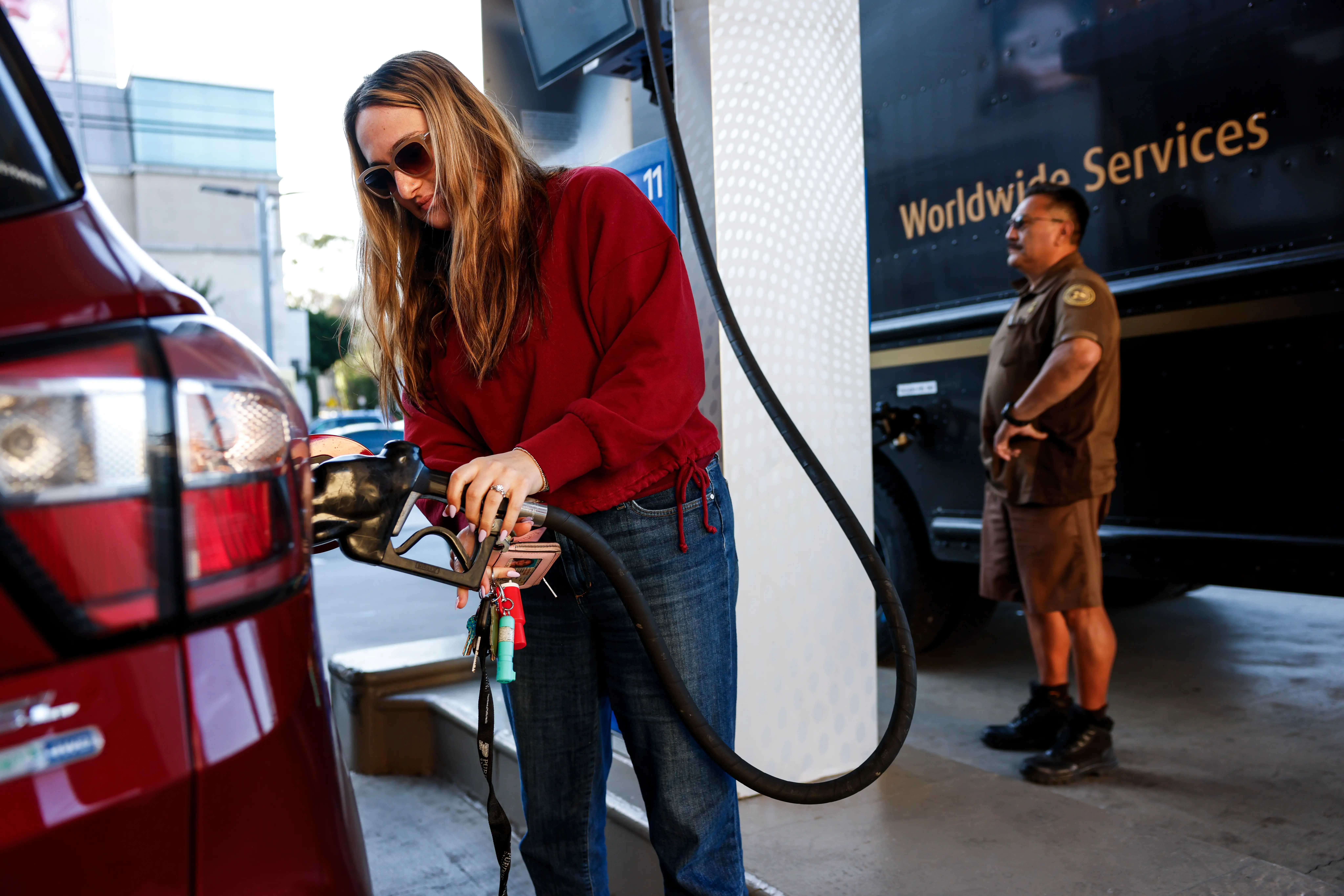 Honor Fuchs, 25, left pumps gas alongside a UPS driver at the Mobil on Beverly Boulevard.