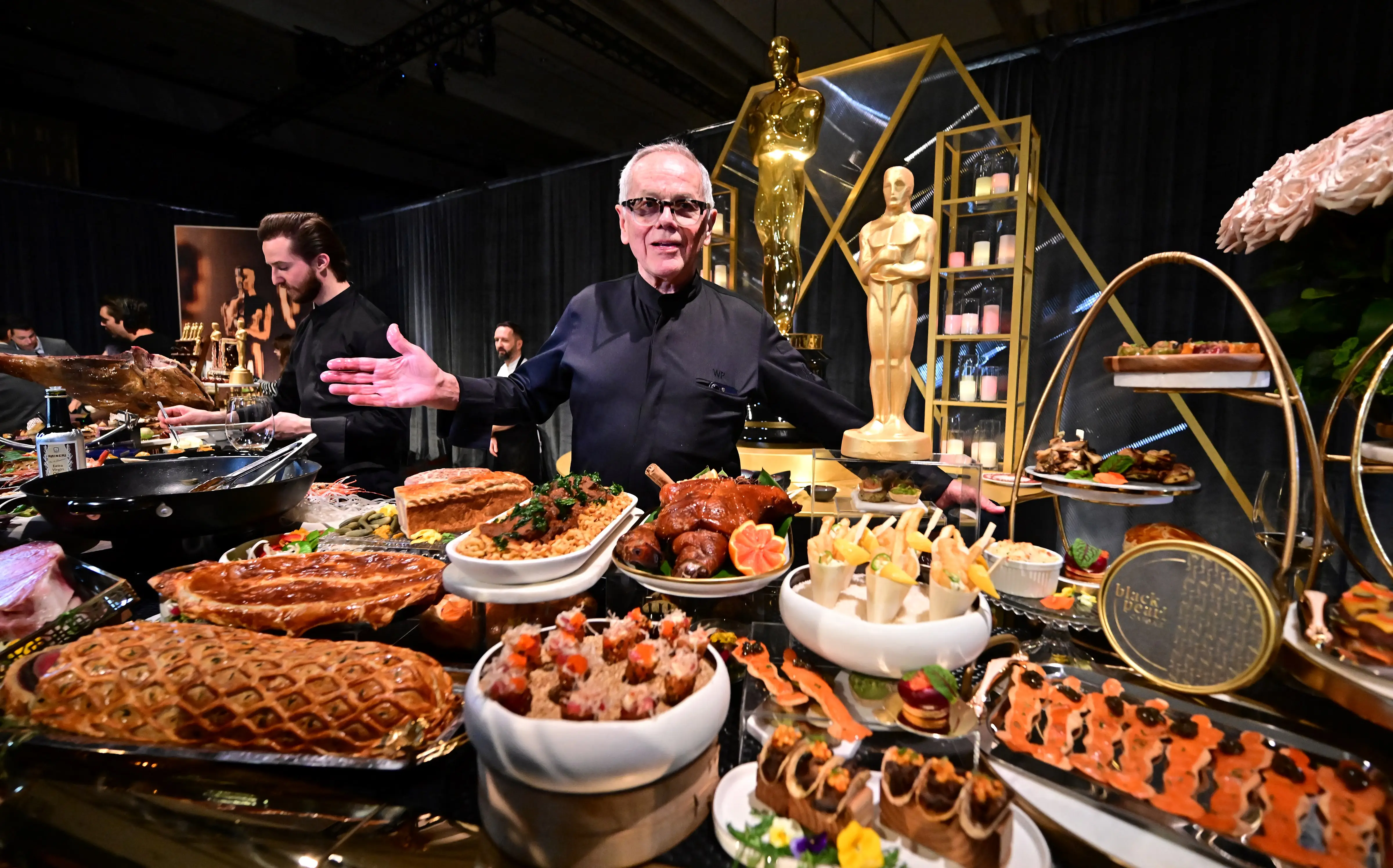 Wolfgang Puck at a buffet of food at the Oscars.