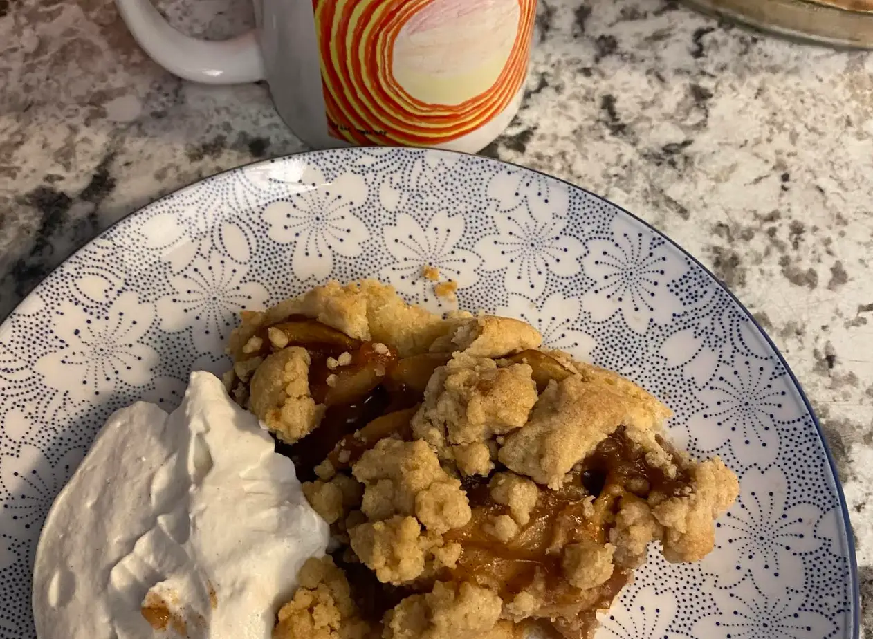 Homemade apple crumble on a plate in the author's house.