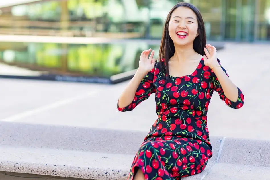 Woman smiling in cherry-print dress