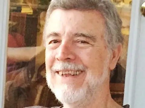 A senior sitting against a window