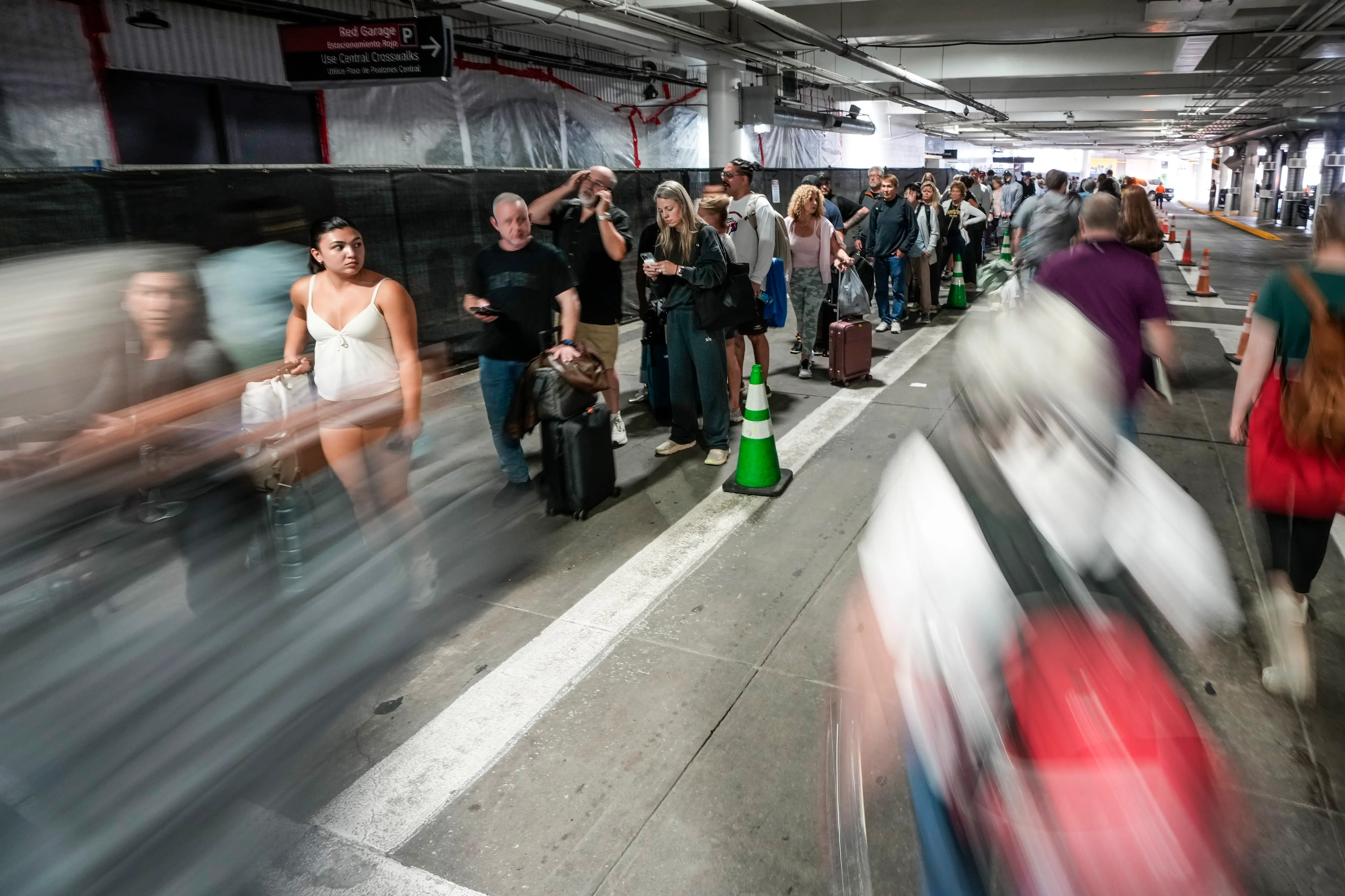 Airline passengers wait in long lines outside the terminal to get through the TSA security screening at William P. Hobby Airport in Houston, Sunday, March 8, 2026