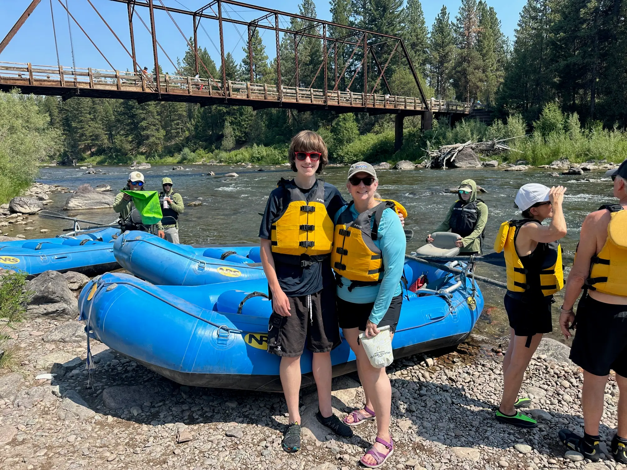 The writer and her son pose alongside a river during a white water rafting trip.