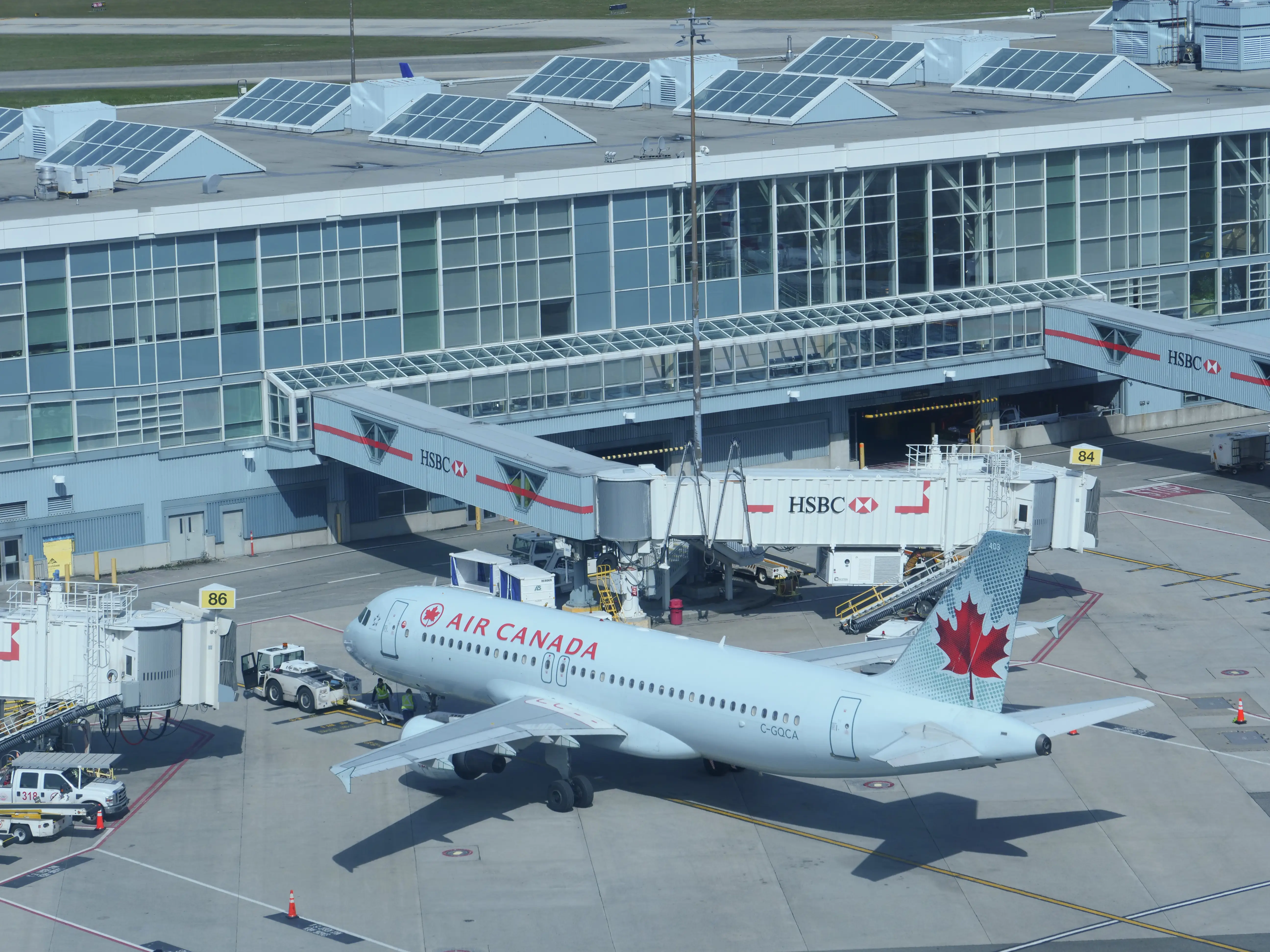 VANCOUVER INTERNATIONAL AIRPORT, CANADA, MARCH 2018: CLOSE UP: Large Air Canada passenger plane is serviced by terminal before boarding. Vancouver International crew preparing airplane for take off.