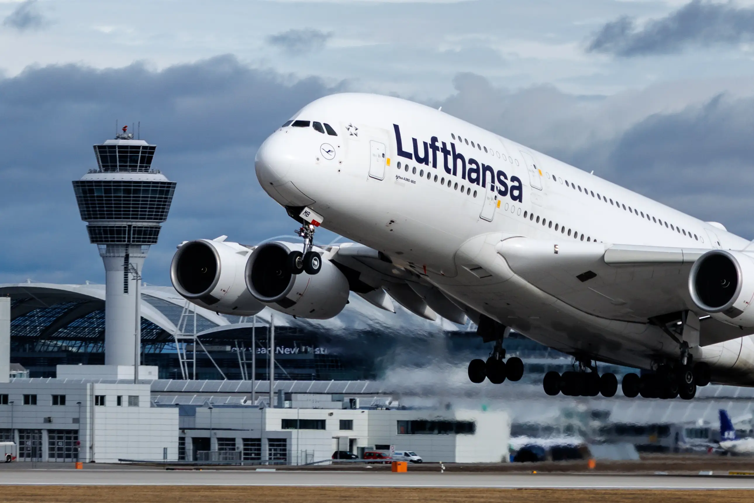 11 February 2026, Bavaria, Munich: General view of Munich Airport (Bavaria, Germany). In the foreground, a Lufthansa aircraft (Airbus A380-800) takes off.