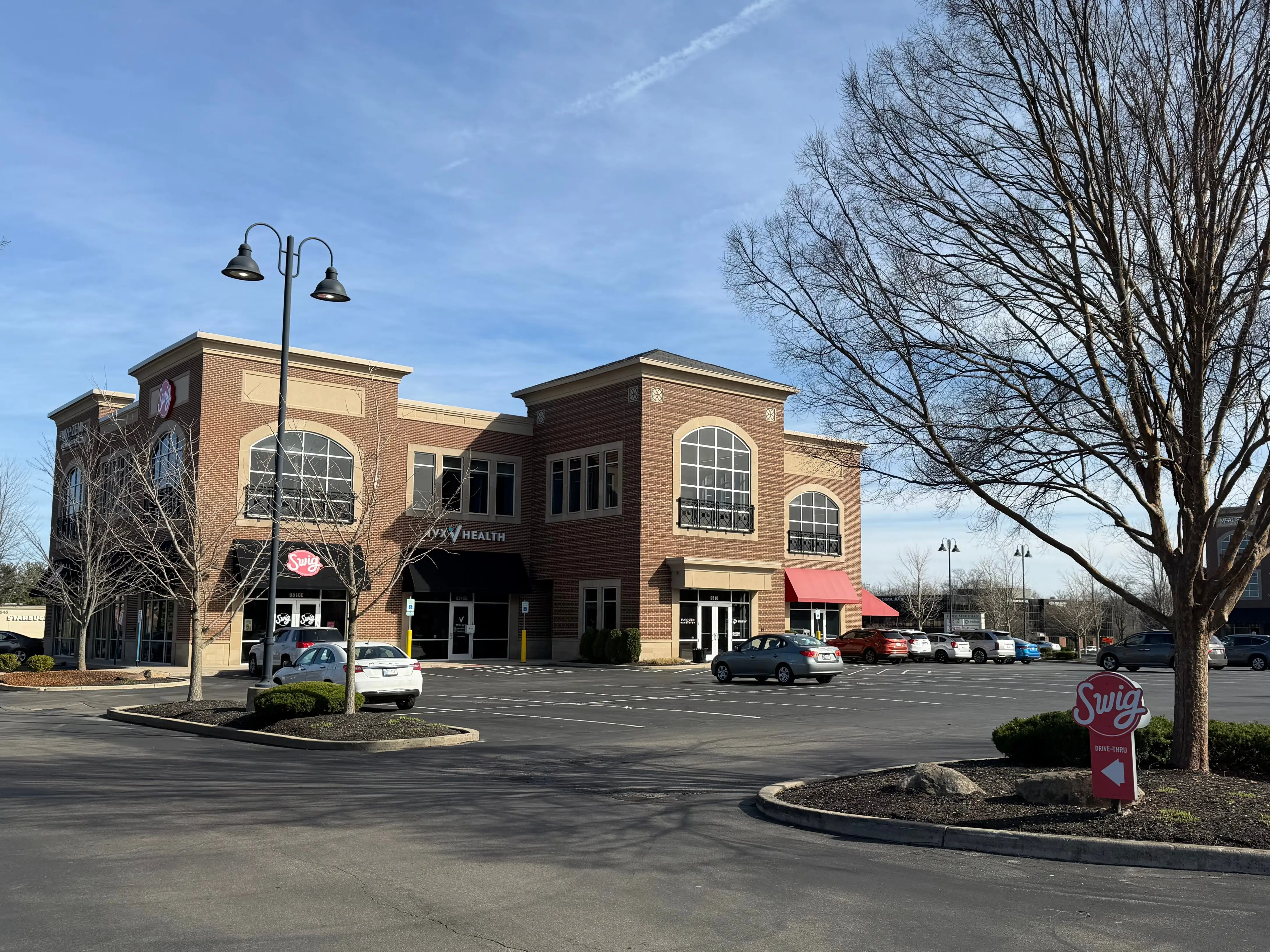 View of building with Swig location  and parking lot in front of it