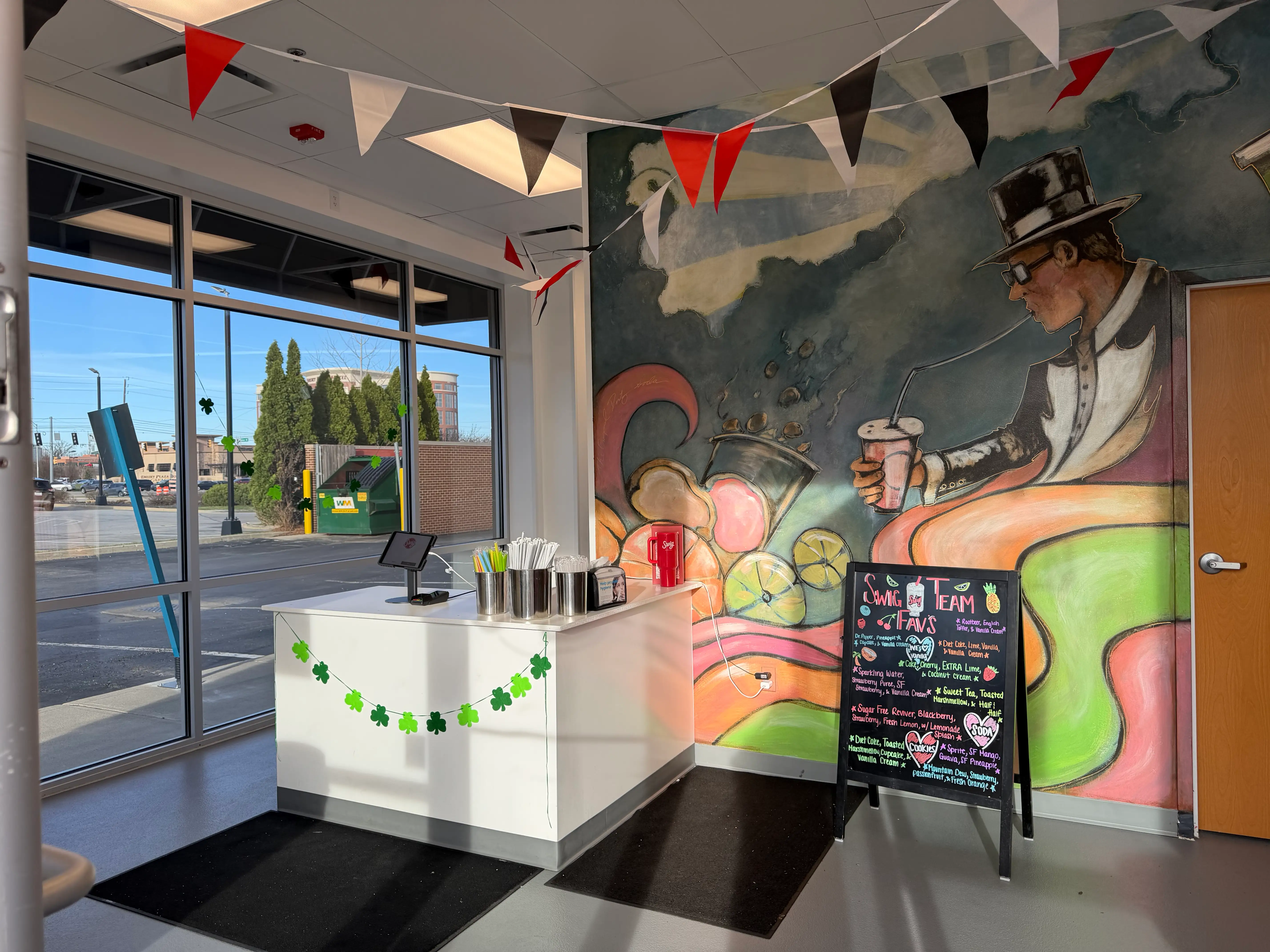 View of Swig ordering counter with one tablet on plain white counter and mural behind it