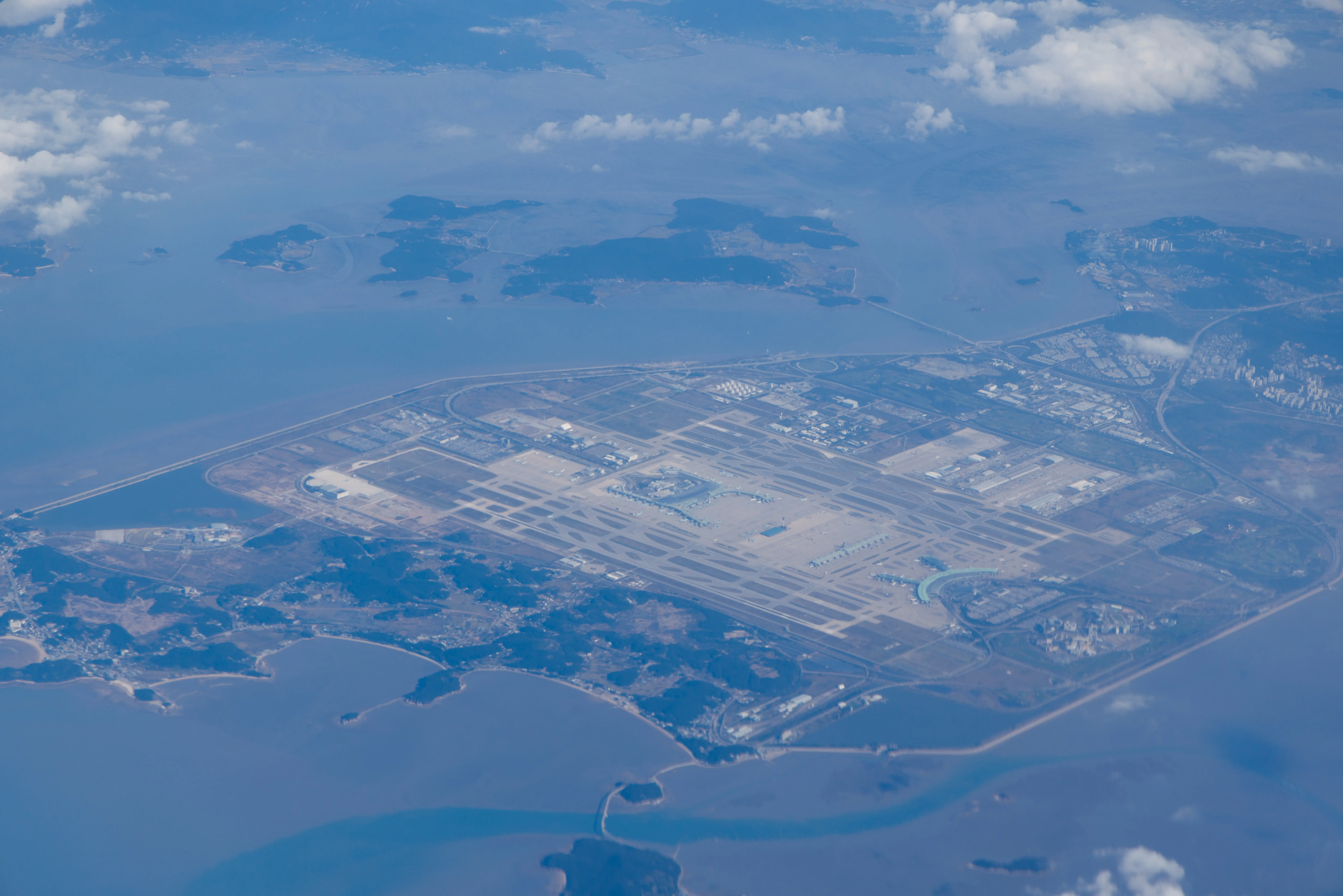Aerial view of Incheon seen from an airplane, overlooking the airport and surrounding coastline.