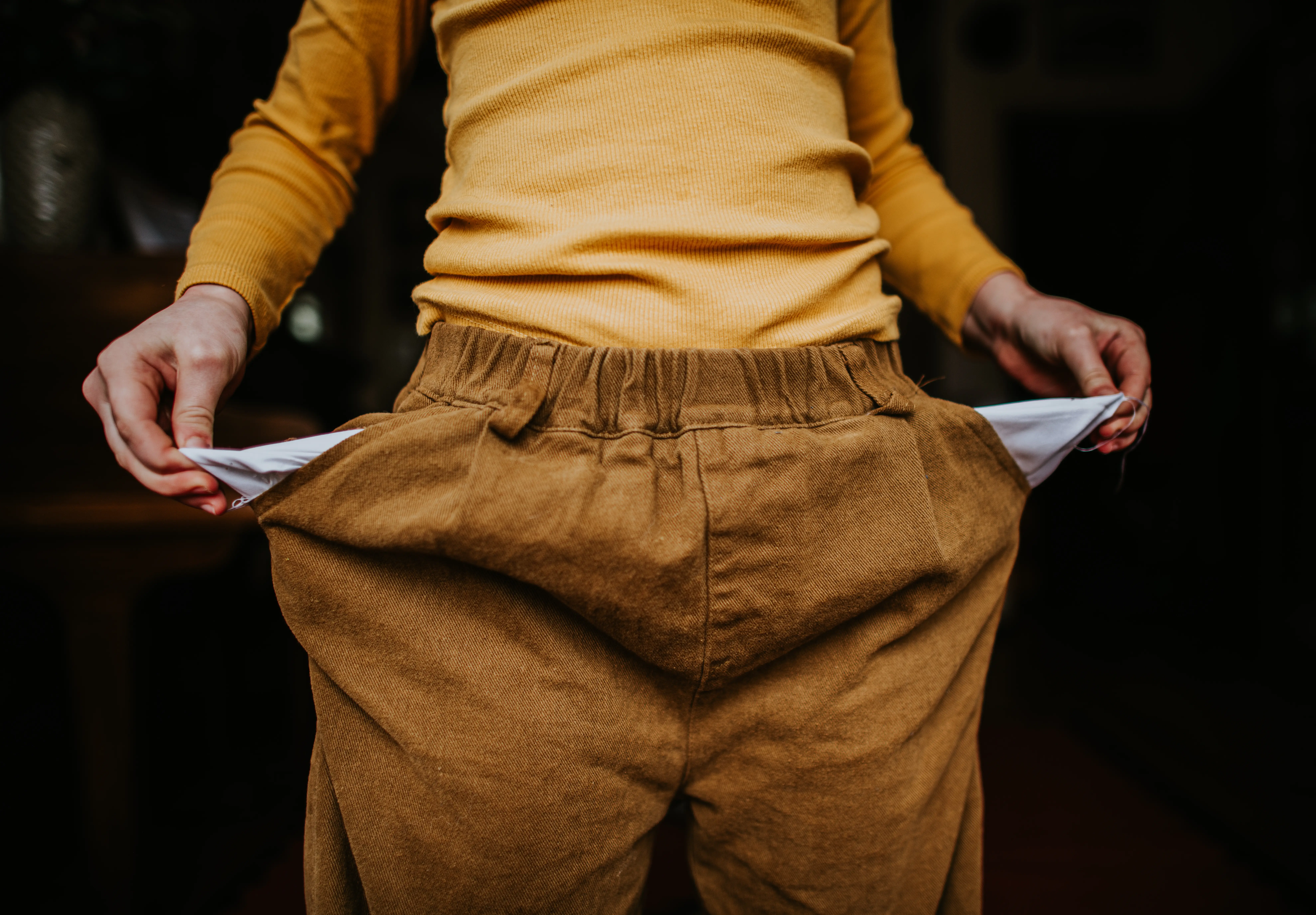 A woman holds our empty pockets.