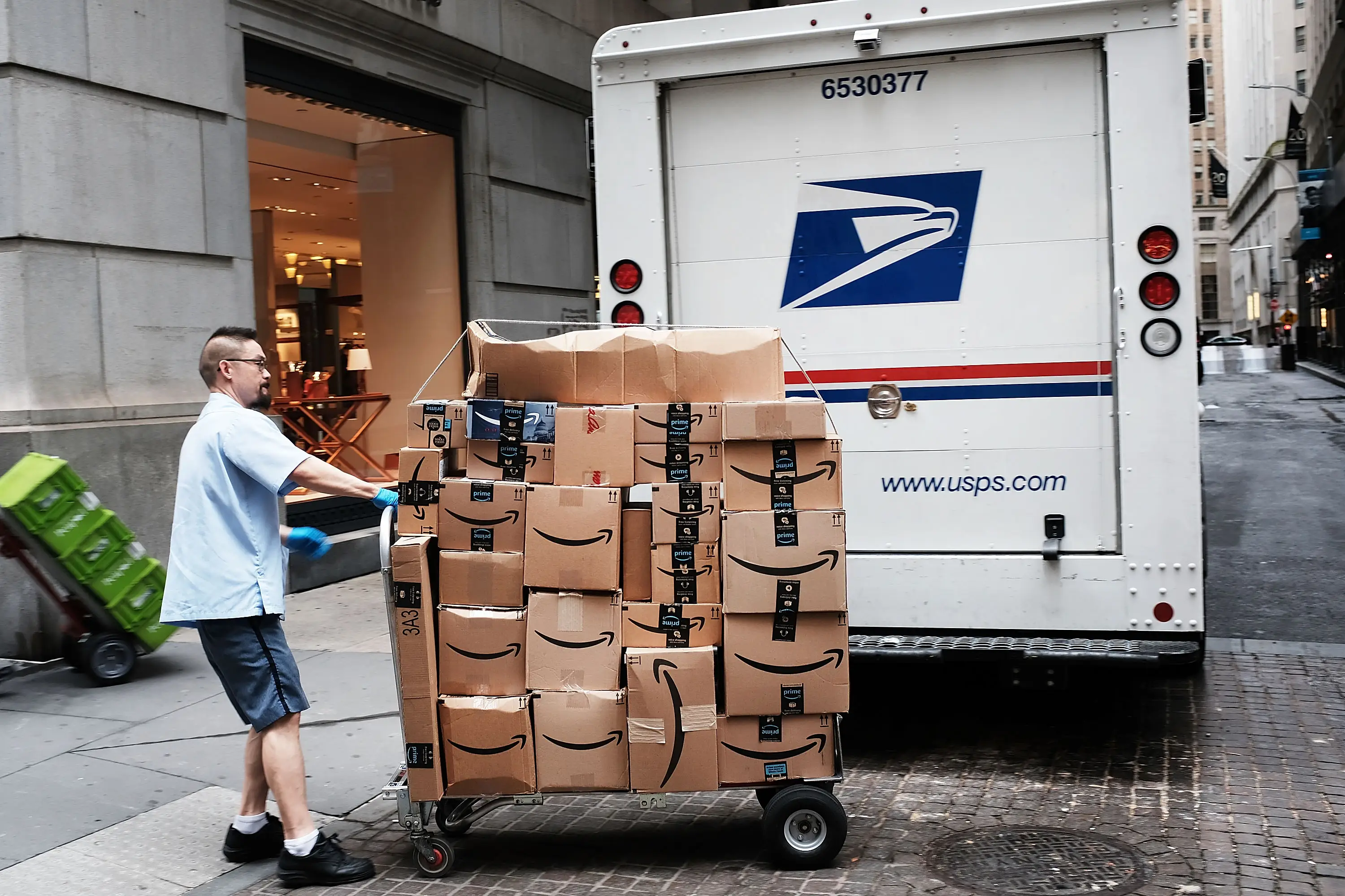 OCTOBER 11: A US Postal worker delivers Amazon boxes outside of the New York Stock Exchange (NYSE) on October 11, 2018 in New York City. Following a massive sell-off of over 800 points yesterday, the Dow Jones Industrial Average fell over 100 points in morning trading. (Photo by Spencer Platt/Getty Images)