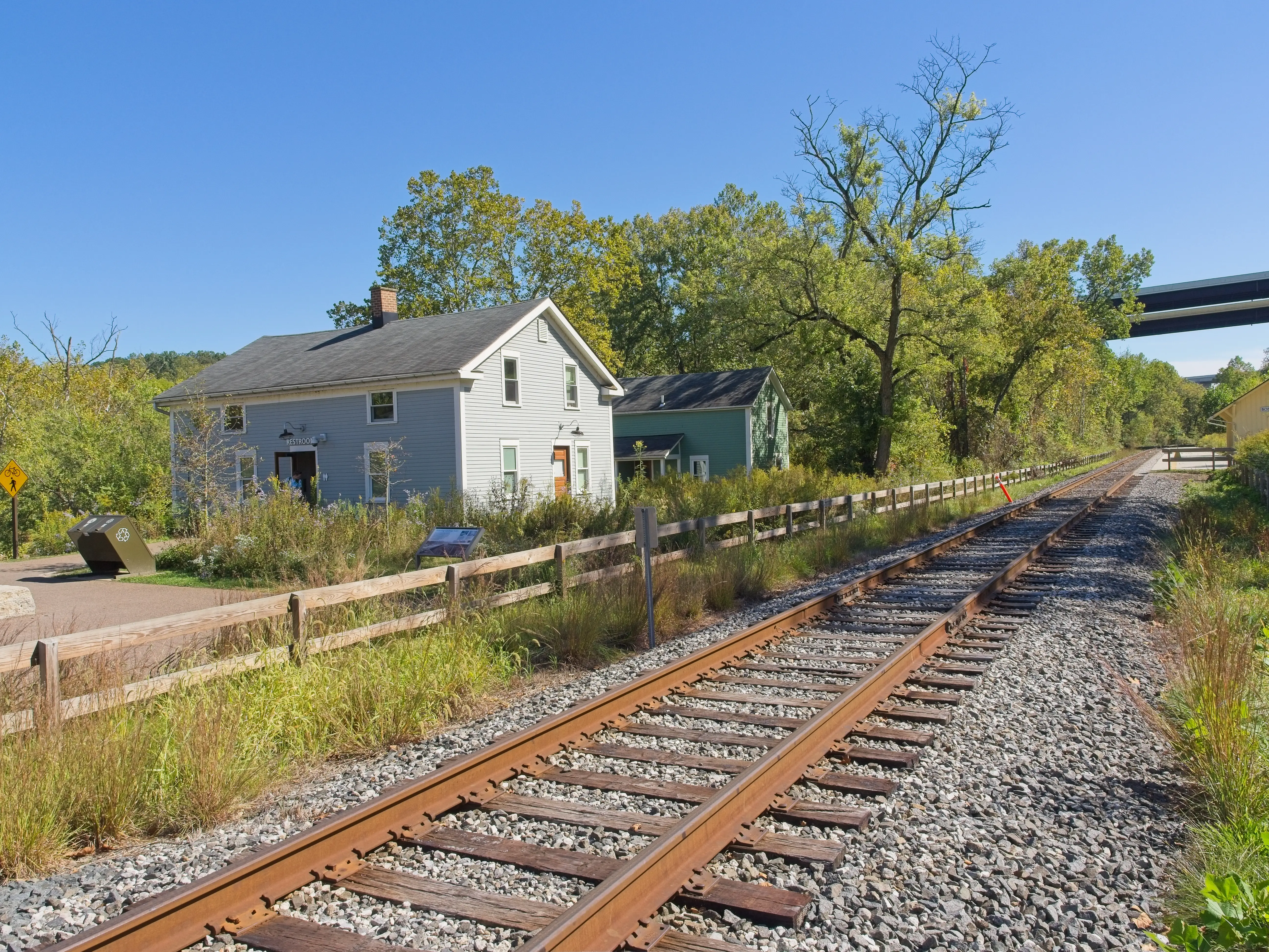 A railroad track with two homes in the background.