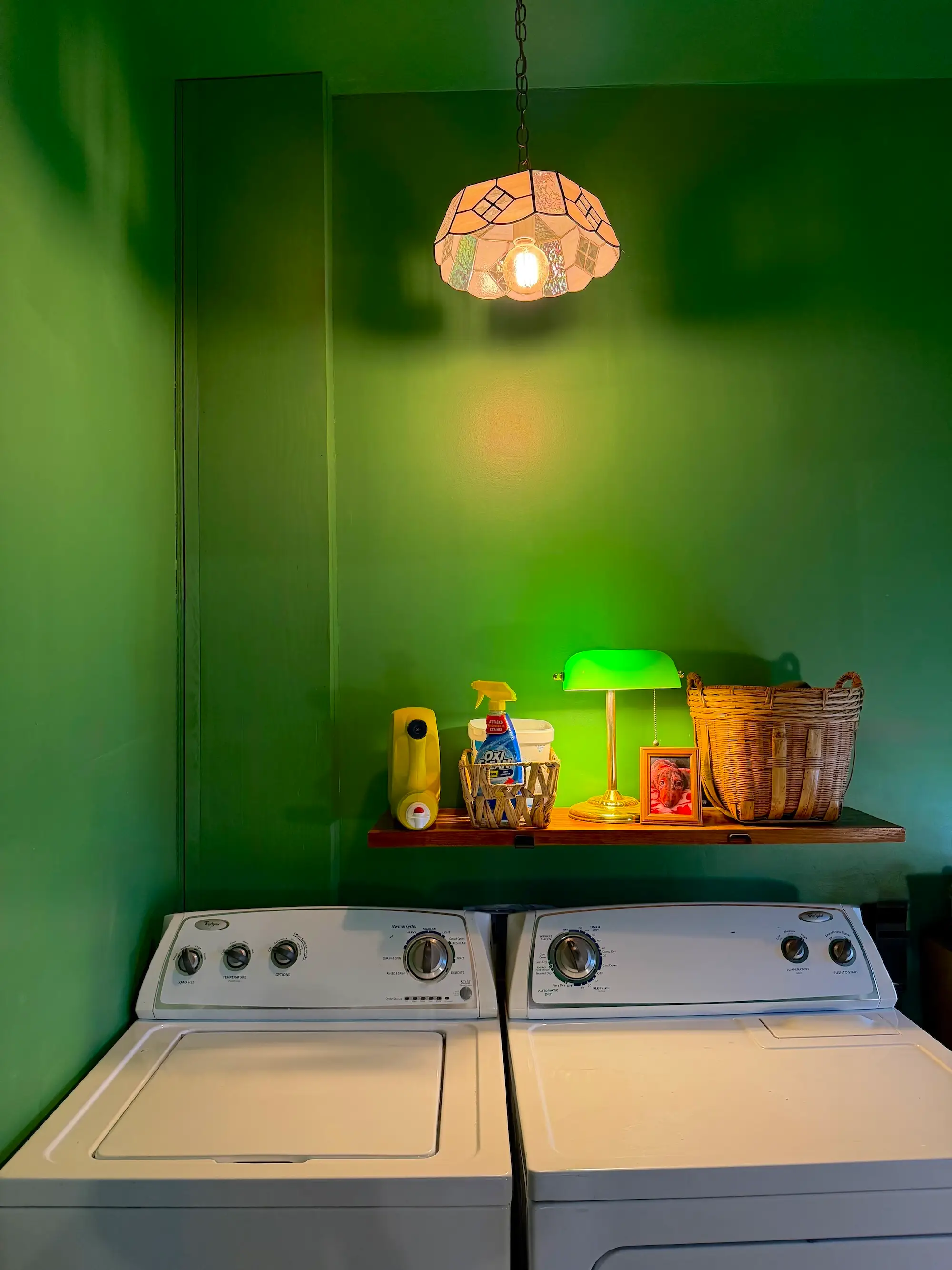 A washer and dryer in a room with green walls.