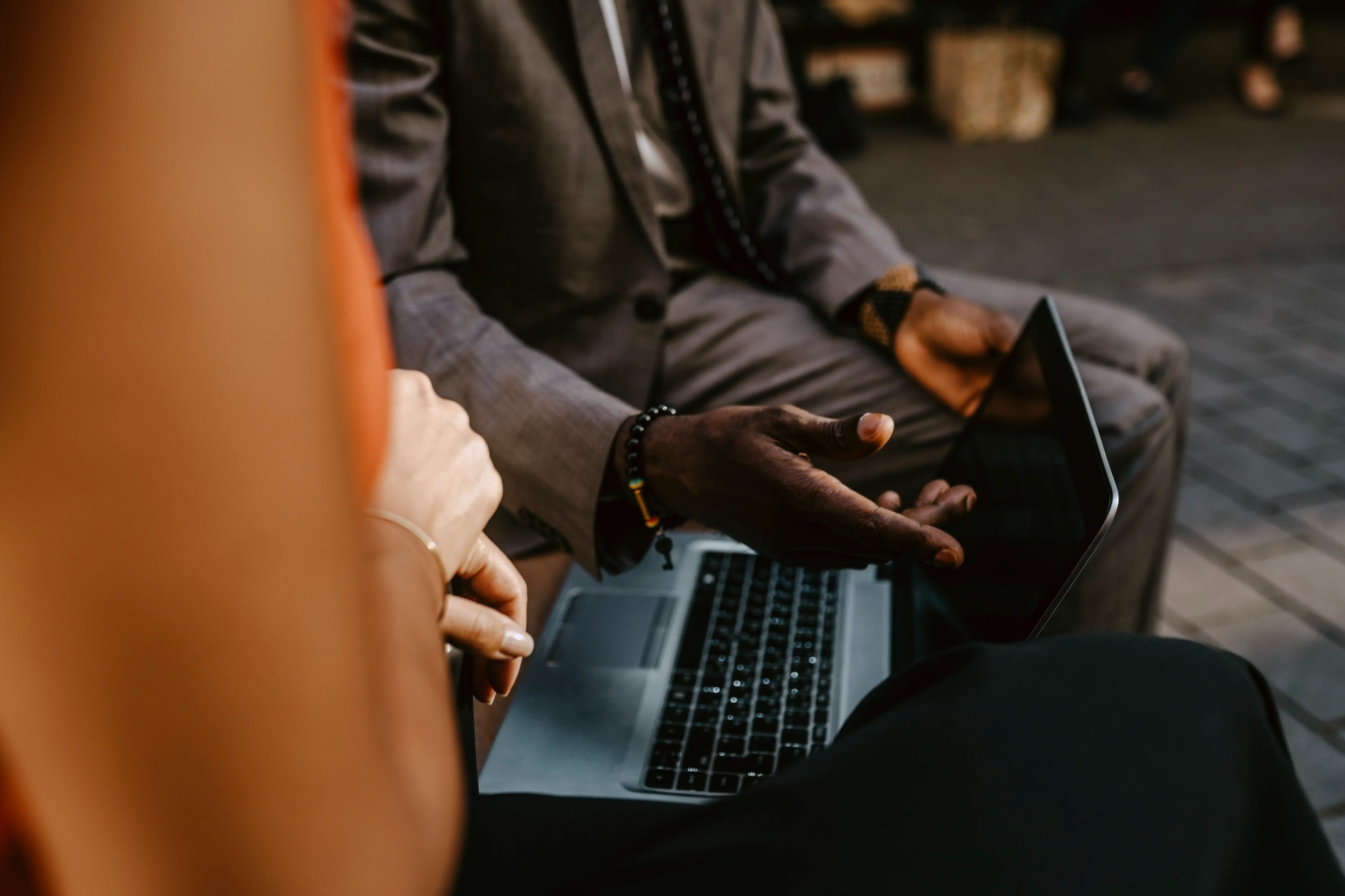 Two coworkers talking over a laptop.