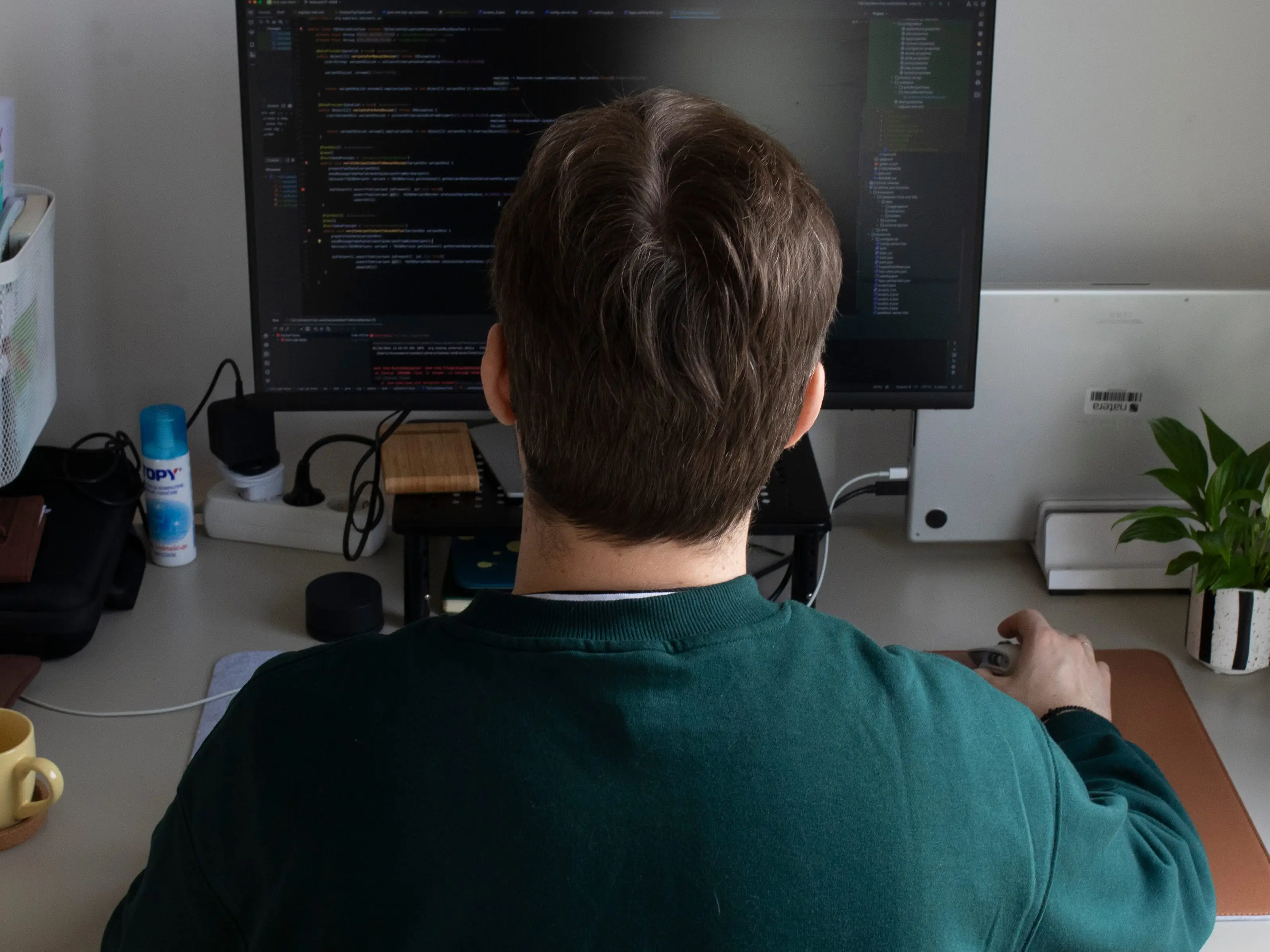A man sitting at a desk working on a computer.