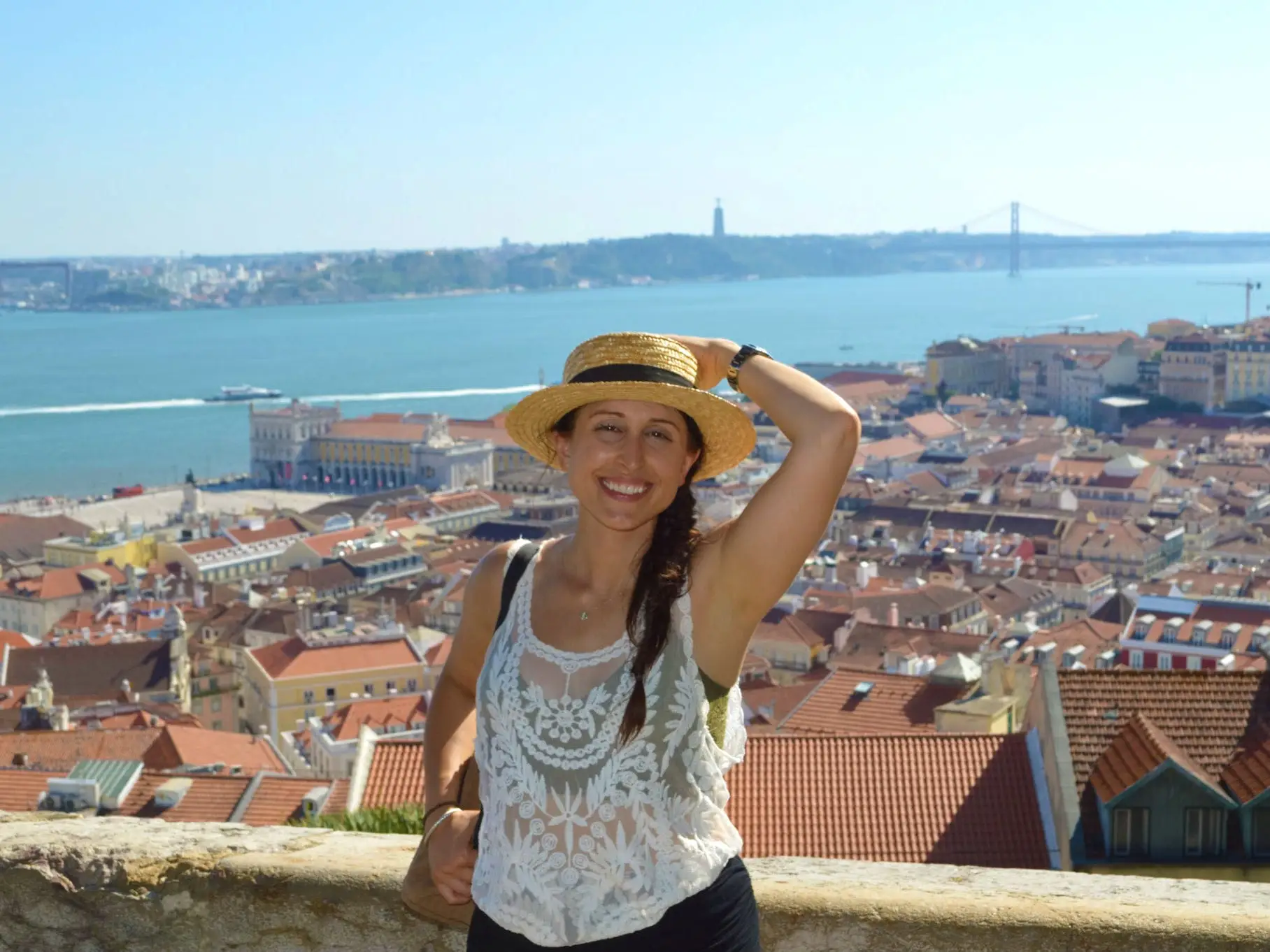 Jaime poses at a viewpoint in Lisbon, with buildings and a river below.