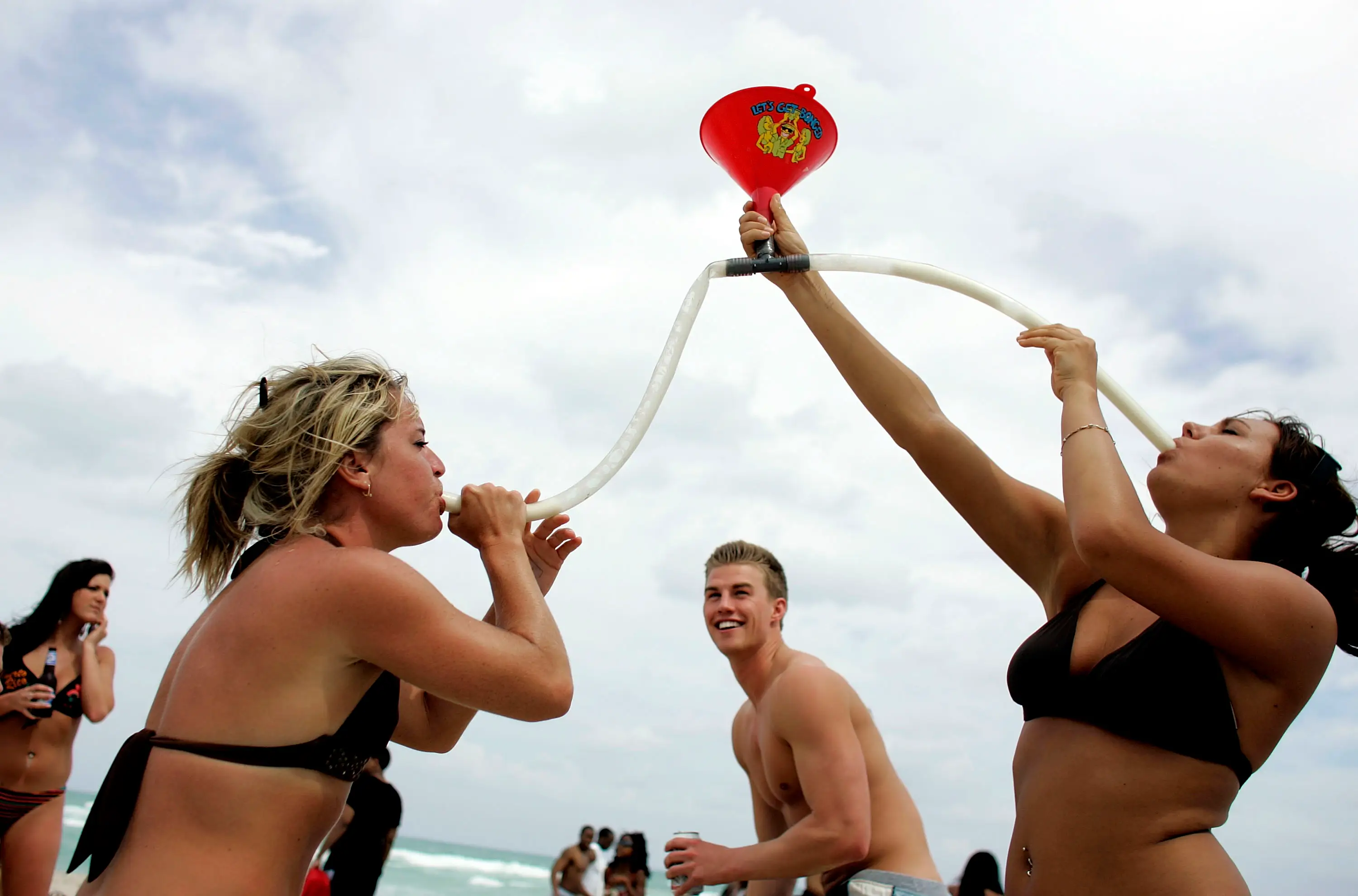 MIAMI BEACH- MARCH 14: Megan Jump (L) and Jenna Haring on spring break from Ball State University, use a funnel to drink beer March 14, 2007 on South Beach in Miami Beach, Florida. Students from universities and colleges around the country are attending spring break which ranges from the end of February to mid-April.