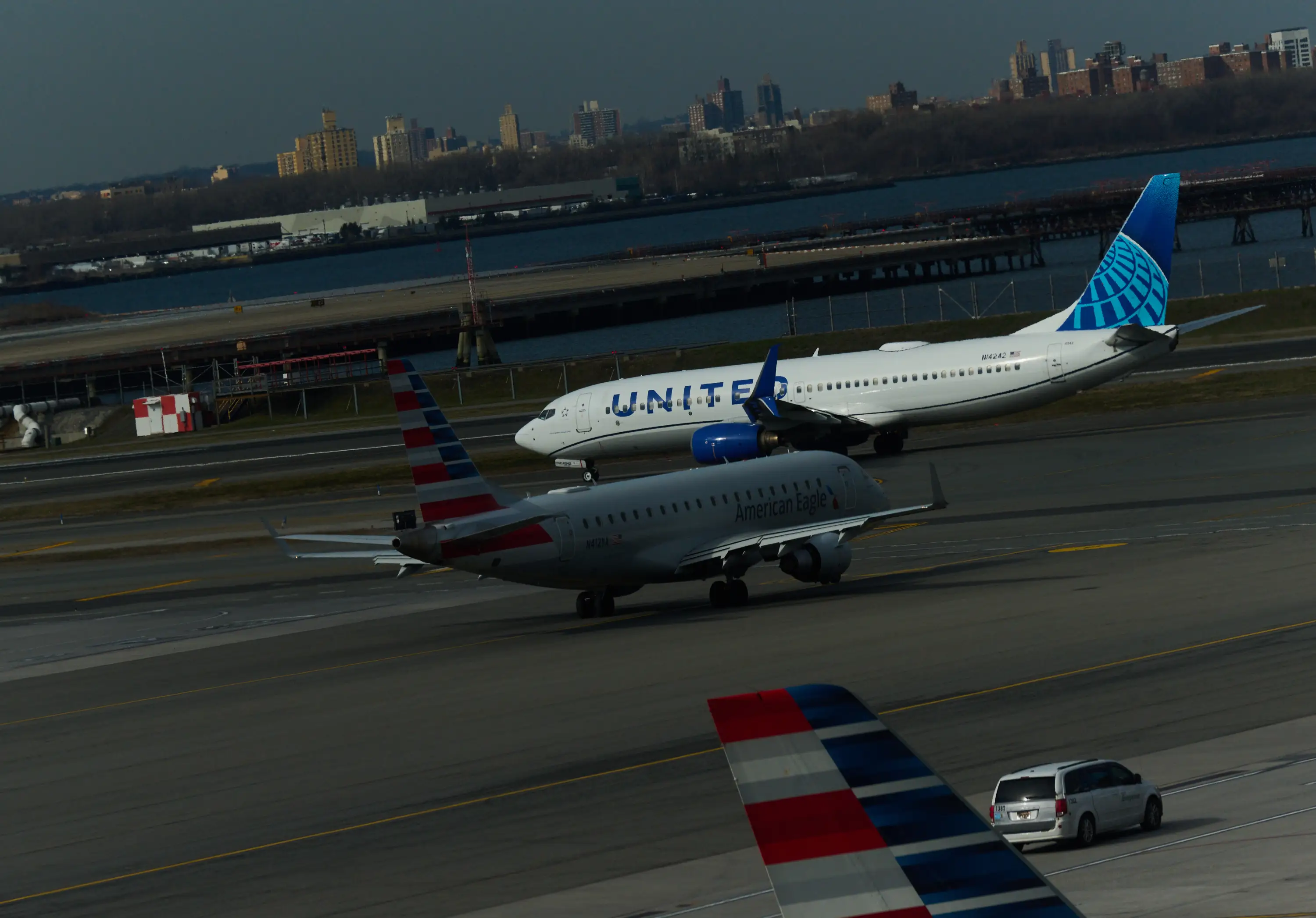 A United Airlines 767-300ER is seen at a gate with the Manhattan skyline in the background at Newark Liberty International Airport in Newark, New Jersey, on March 18, 2026. US airport security officers missed their first full paycheck on March 13 as a partial funding shutdown of the government approached the one-month mark, with no