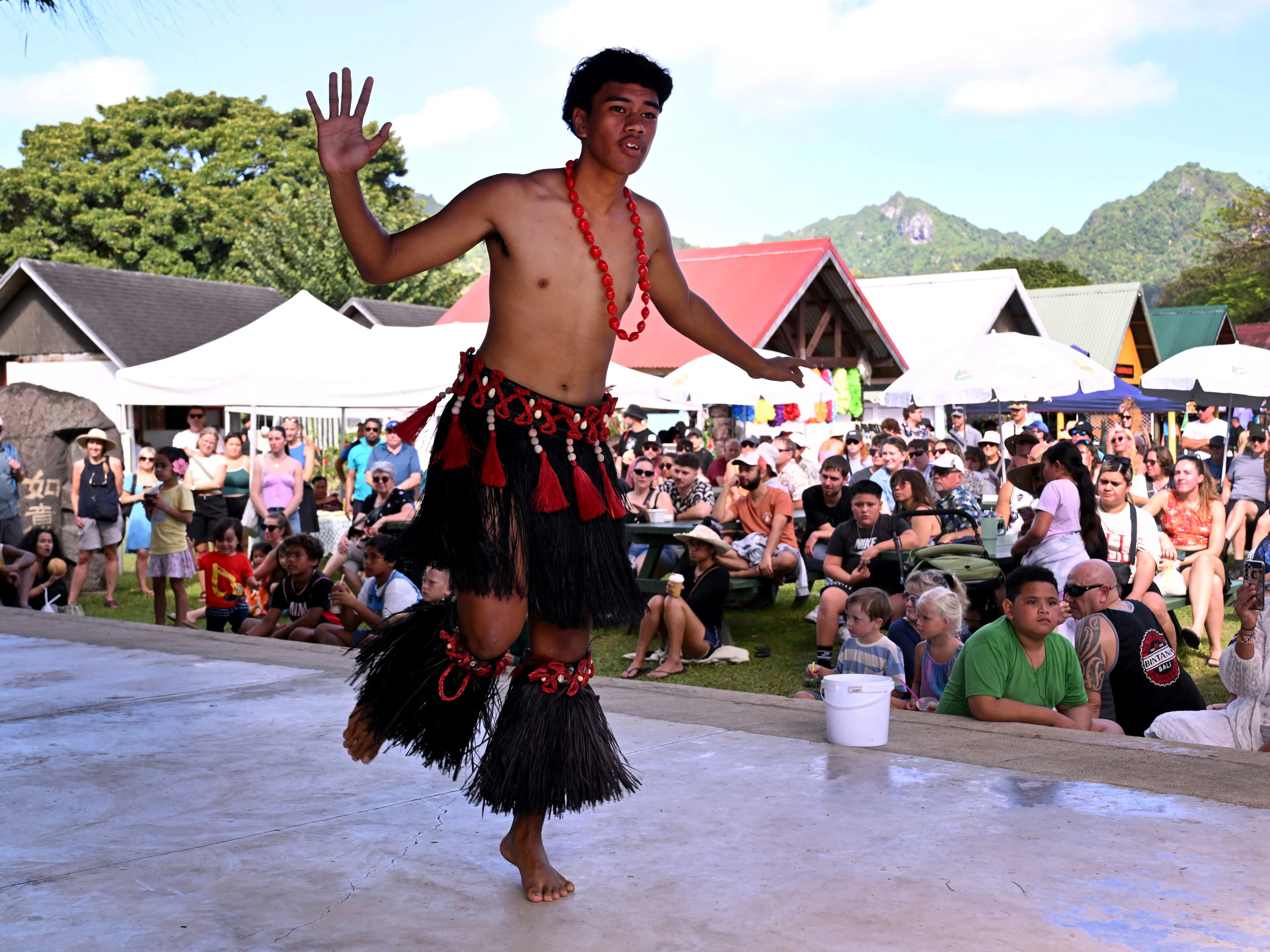 A traditional dancer from The Cook Islands wearing a necklace and outfit made of straw.