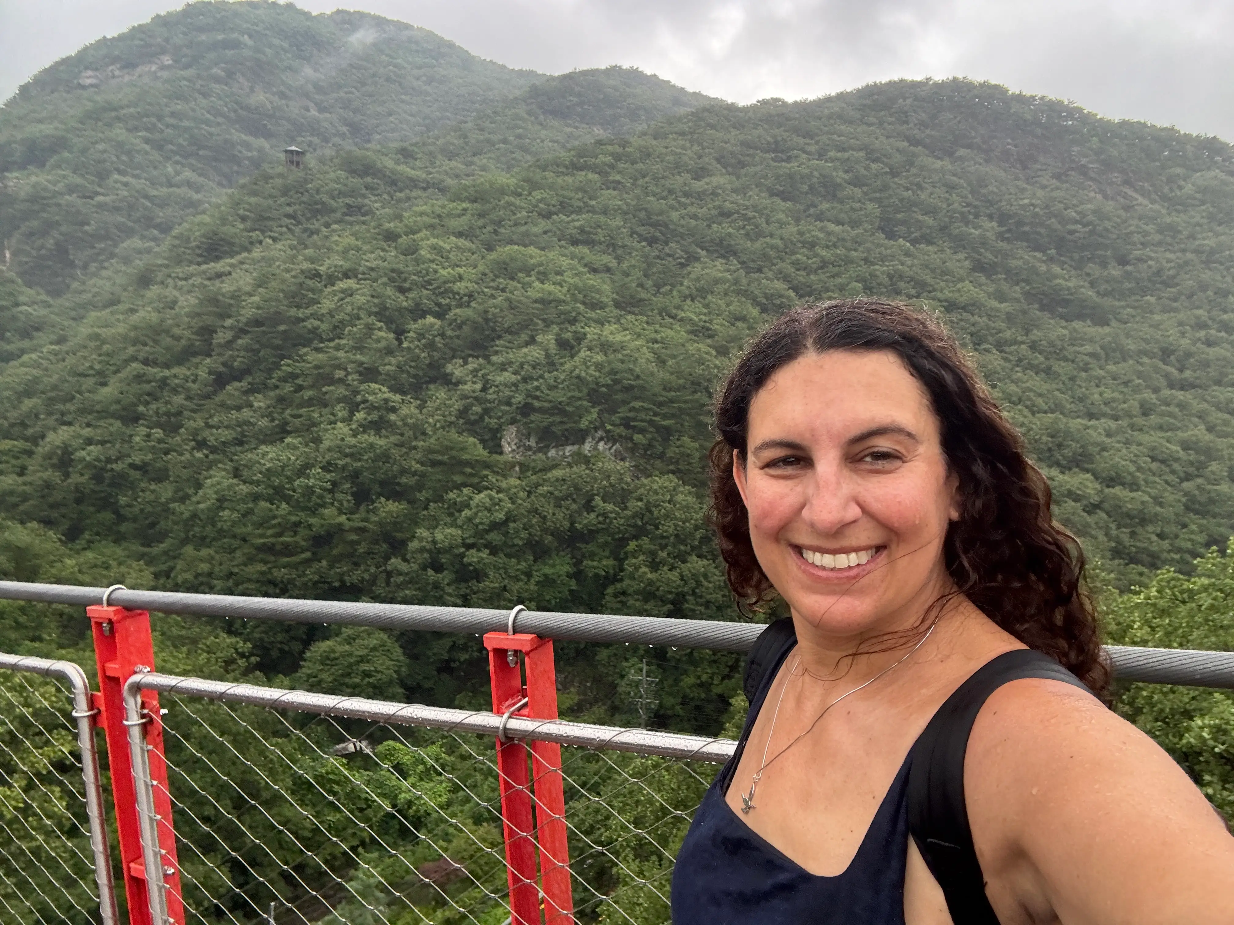 Author Jamie Davis Smith smiling in front of view of trees in distance