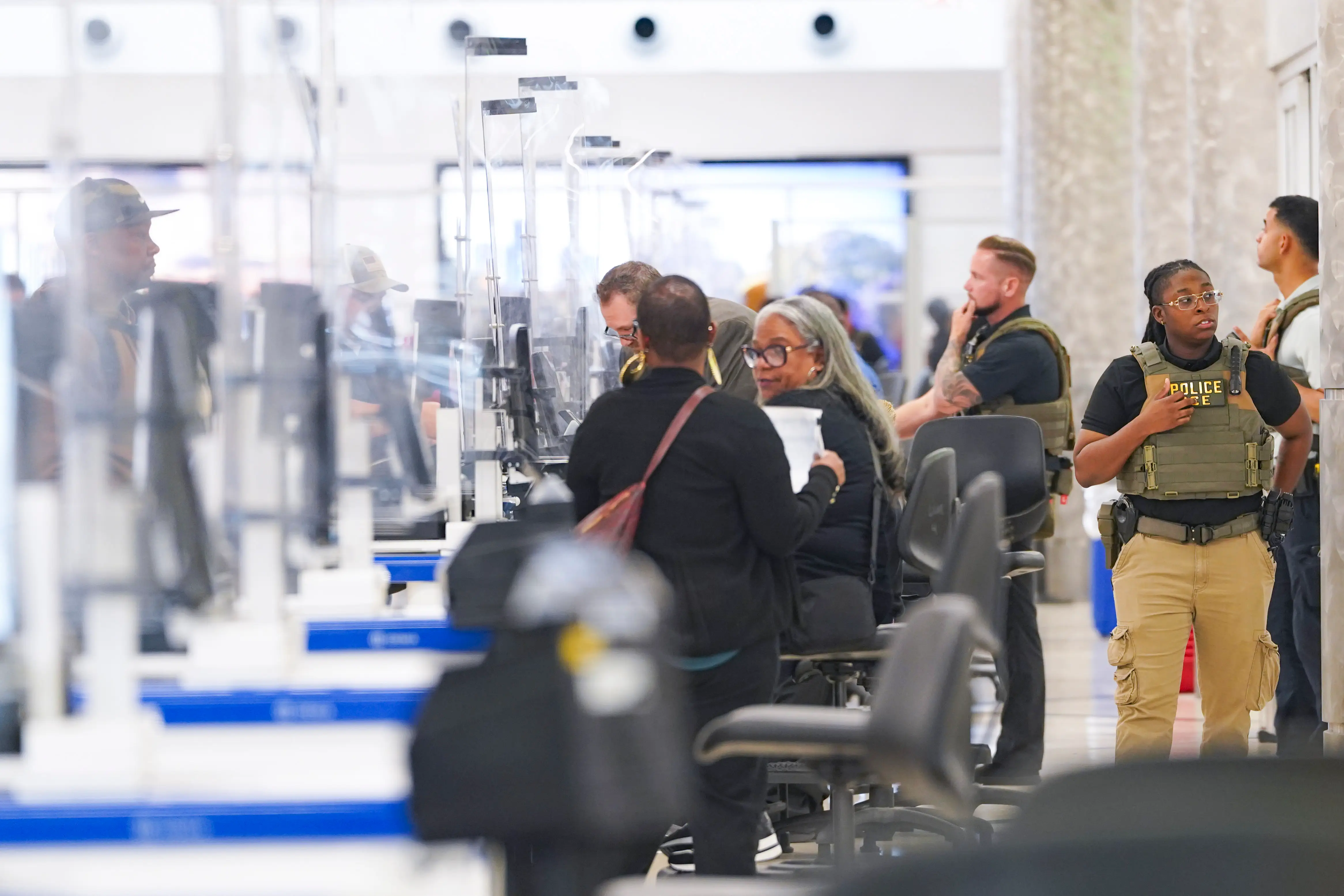 ICE agents stand behind TSA checking travelers through security at Atlanta Hartsfield-Jackson International Airport on March 23, 2026 in Atlanta, Georgia.