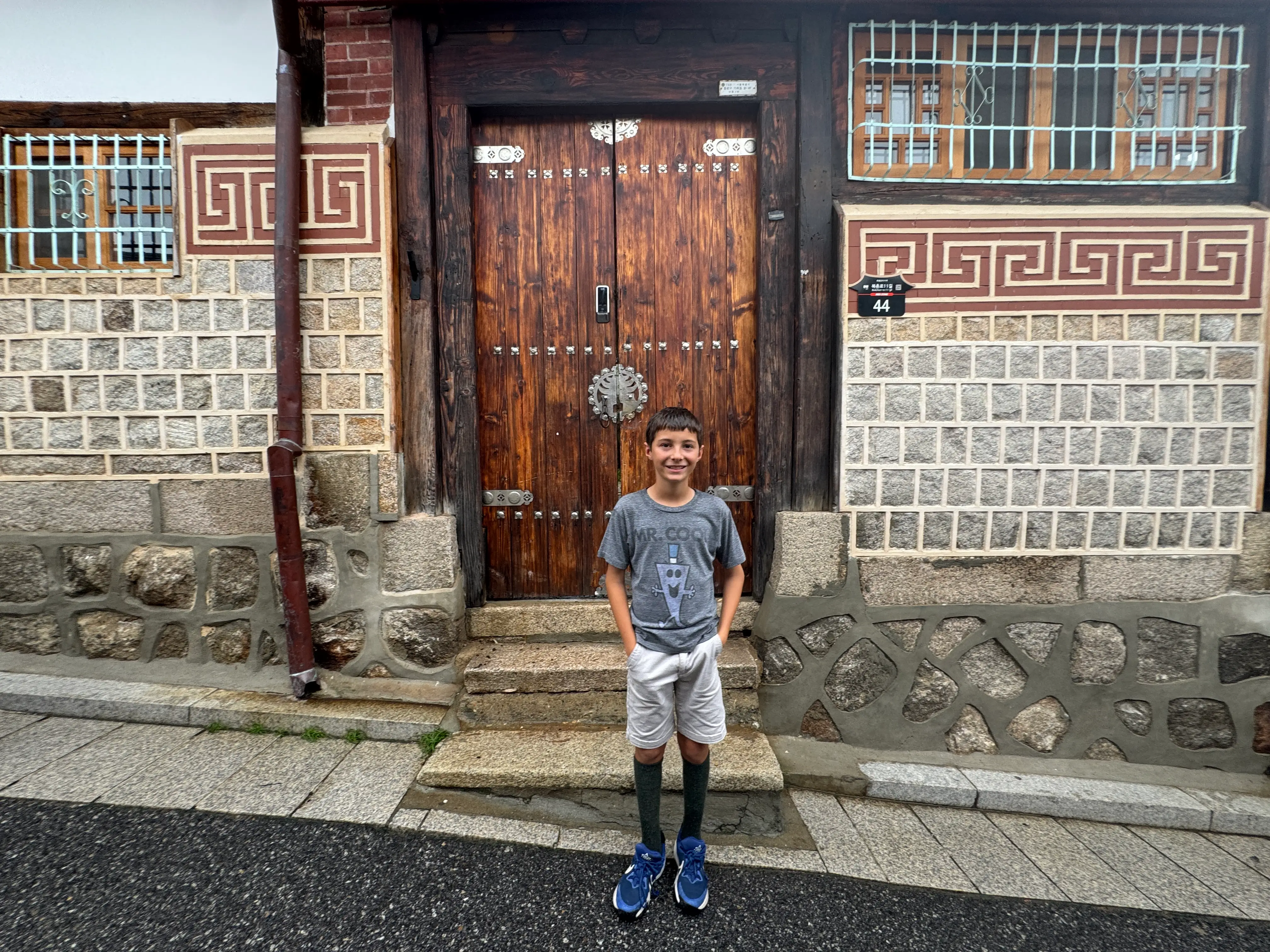 kid smiling in front of door in Seoul