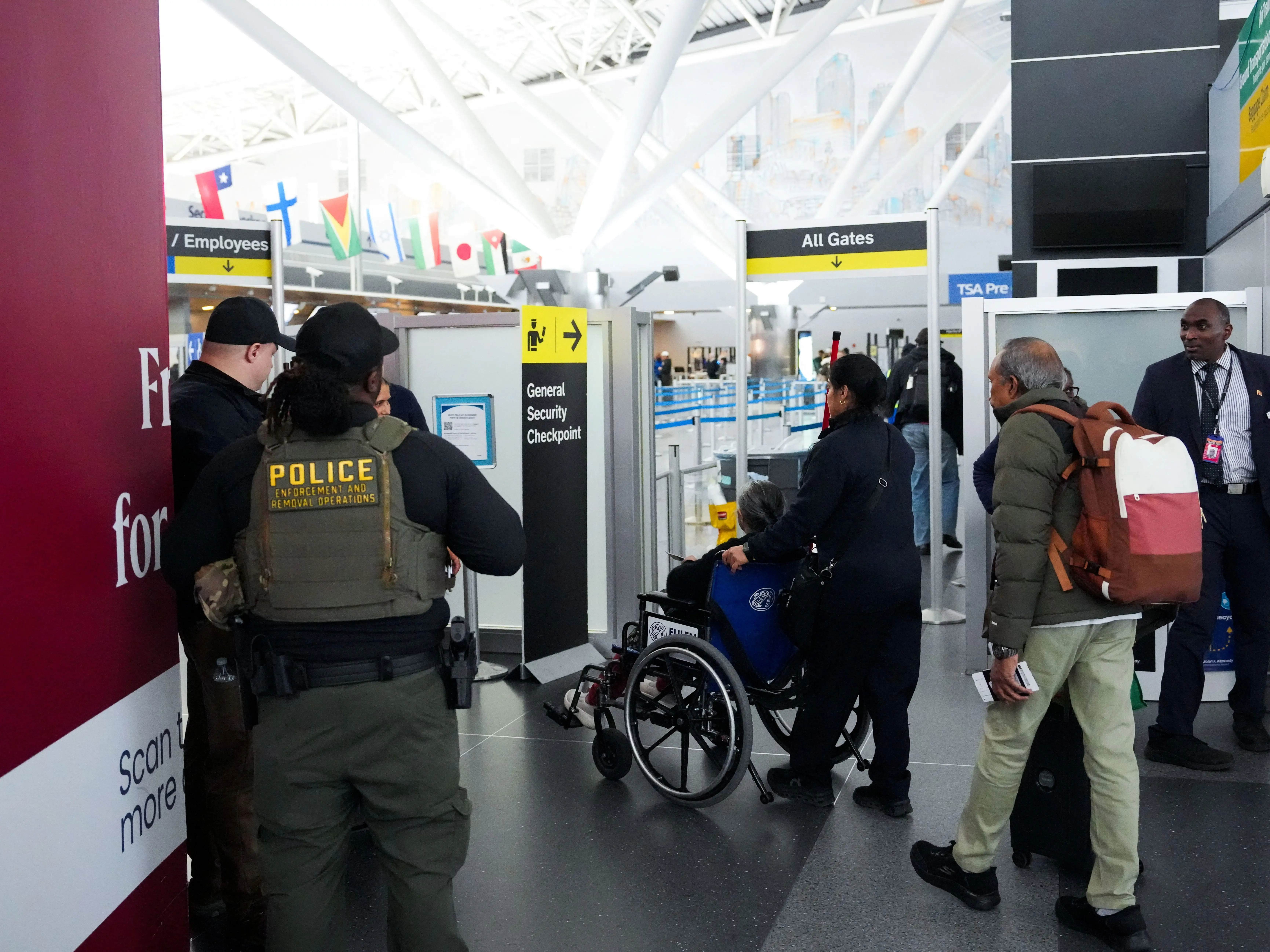 Immigration and Customs Enforcement (ICE) agents stand by a security checkpoint at John F. Kennedy International Airport, New York City, U.S. March 23, 2026.