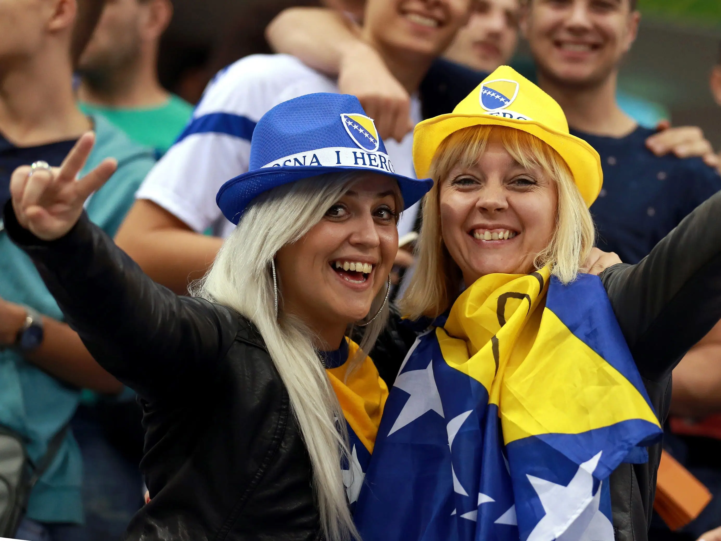 Two fans in Bosnia and Herzegovina hats.