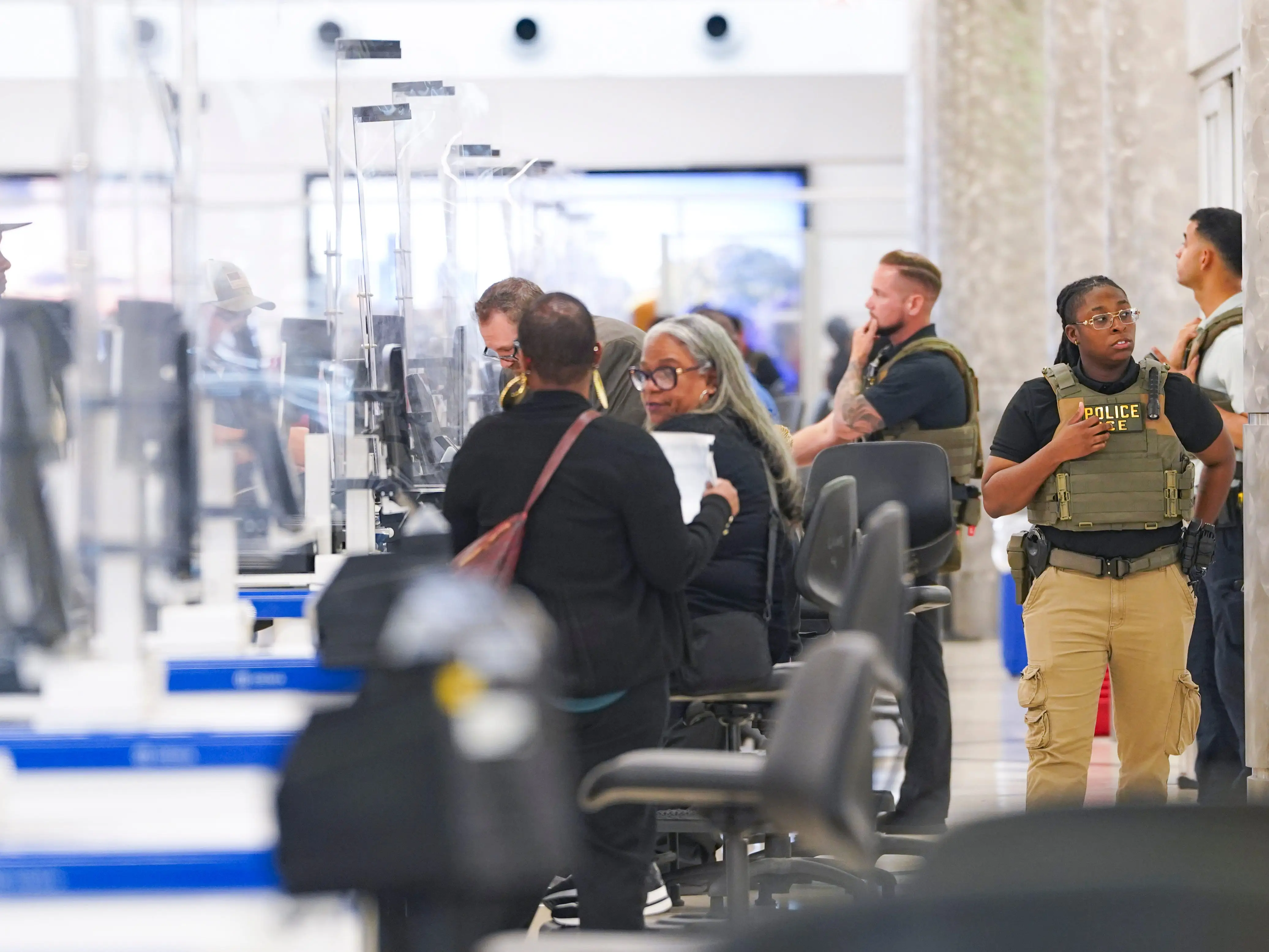 ICE agents stand behind TSA checking travelers through security at Atlanta Hartsfield-Jackson International Airport on March 23, 2026 in Atlanta, Georgia.