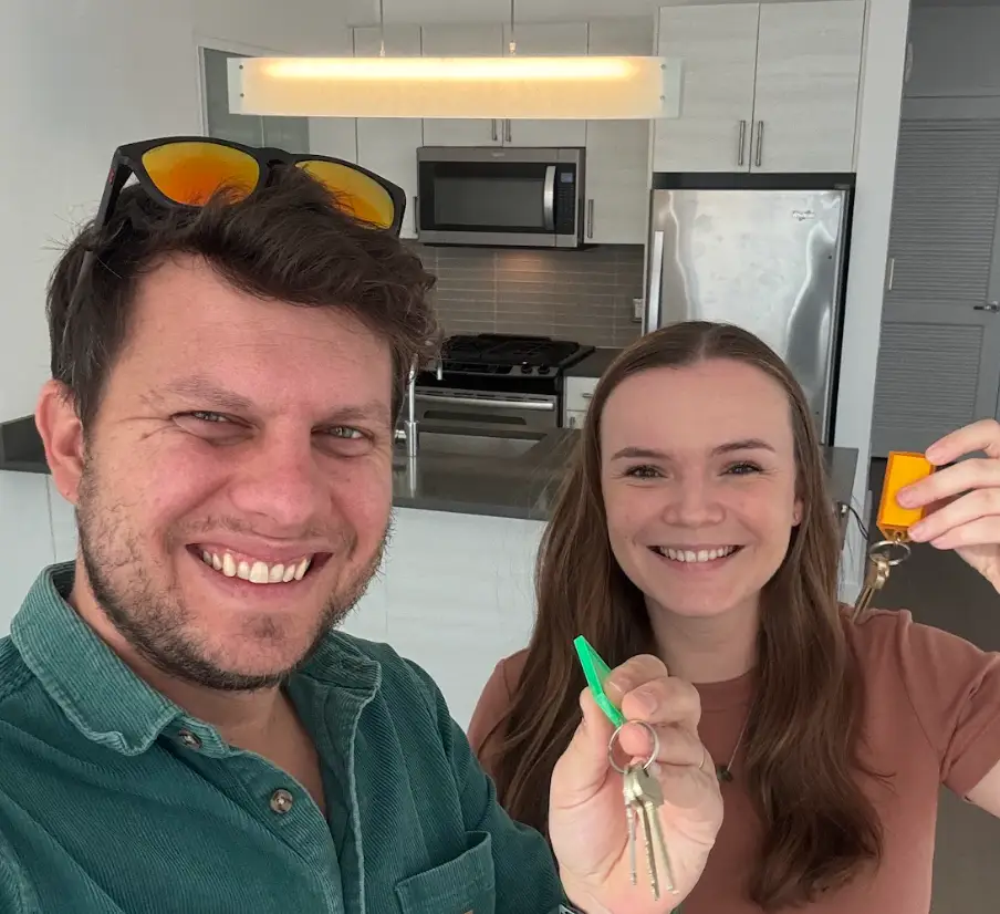 The writer and her husband holding up keys to their apartment in New York City.