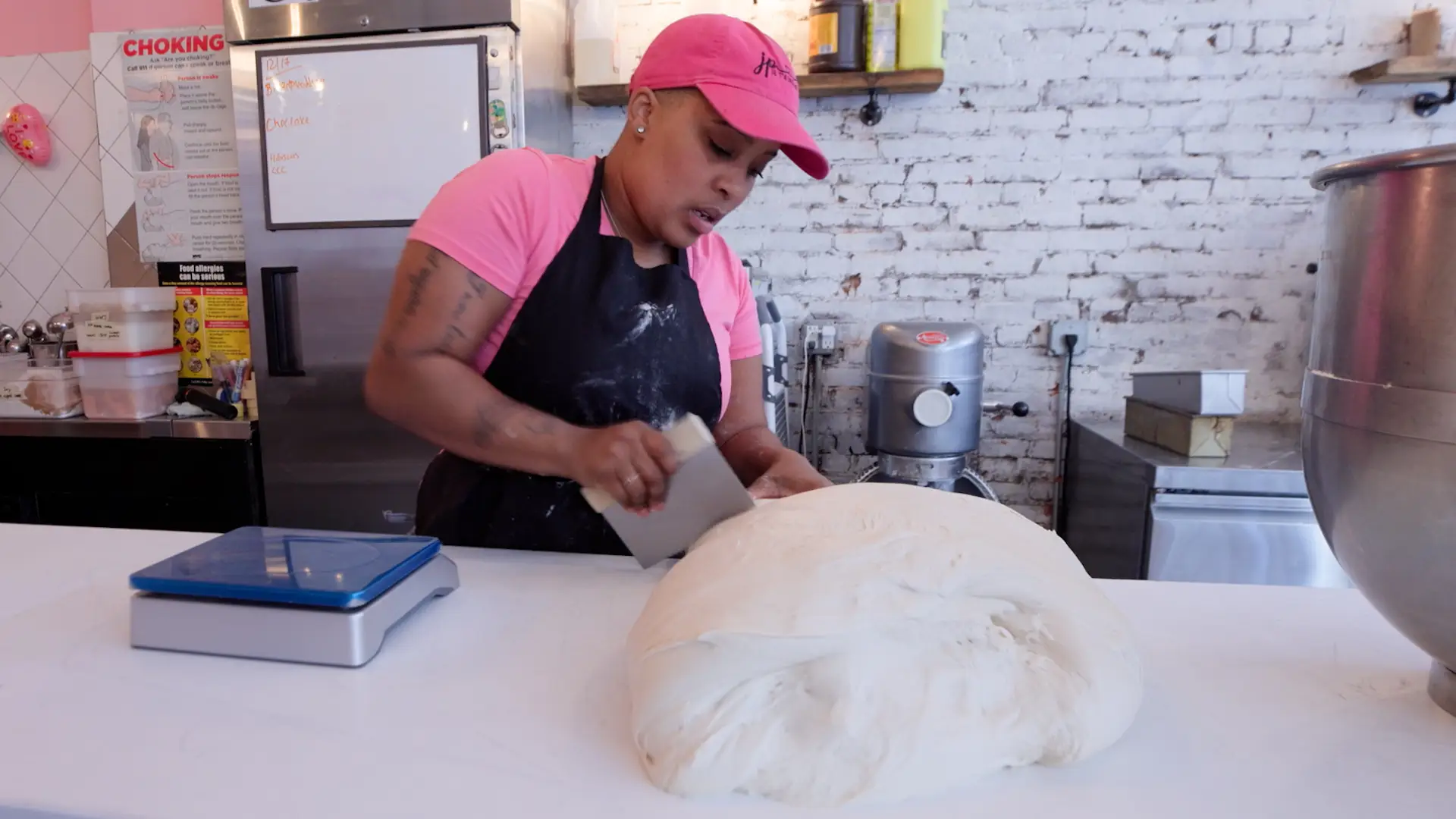 Jatee Kearsley cutting rolls of dough in her bakery.
