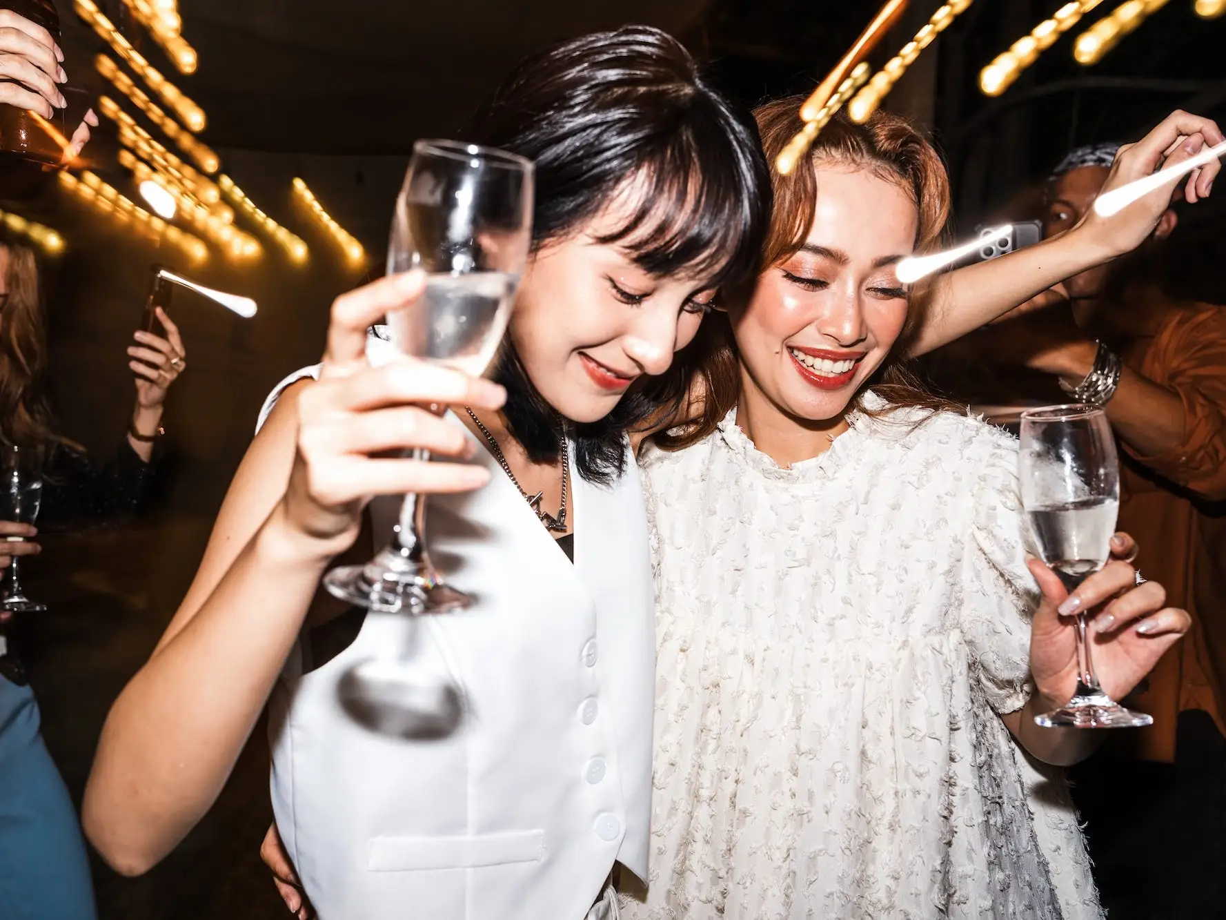 Two brides walk through sparklers together.