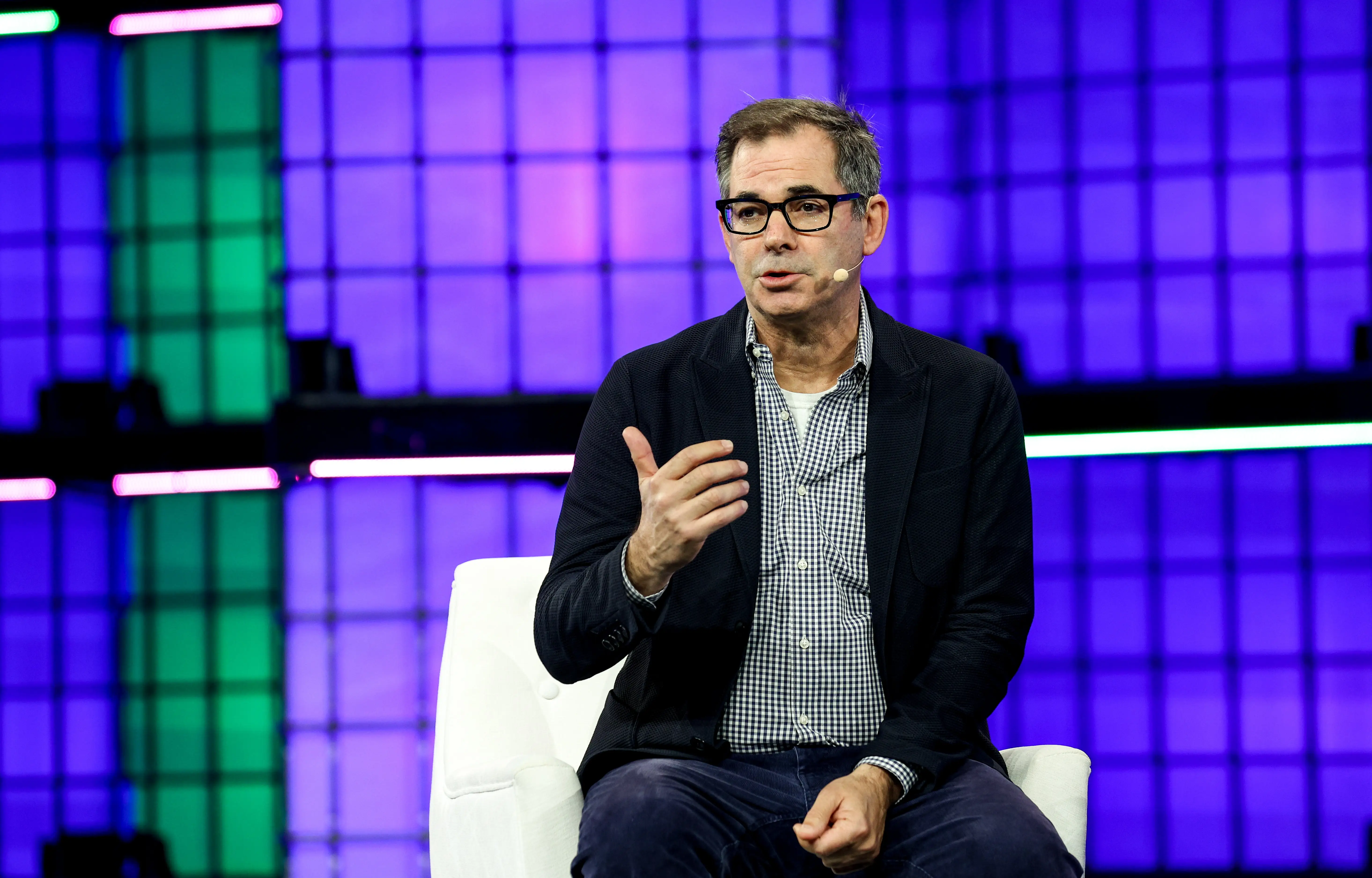 Michael Intrator, the CEO of CoreWeave, sits on a white chair onstage.