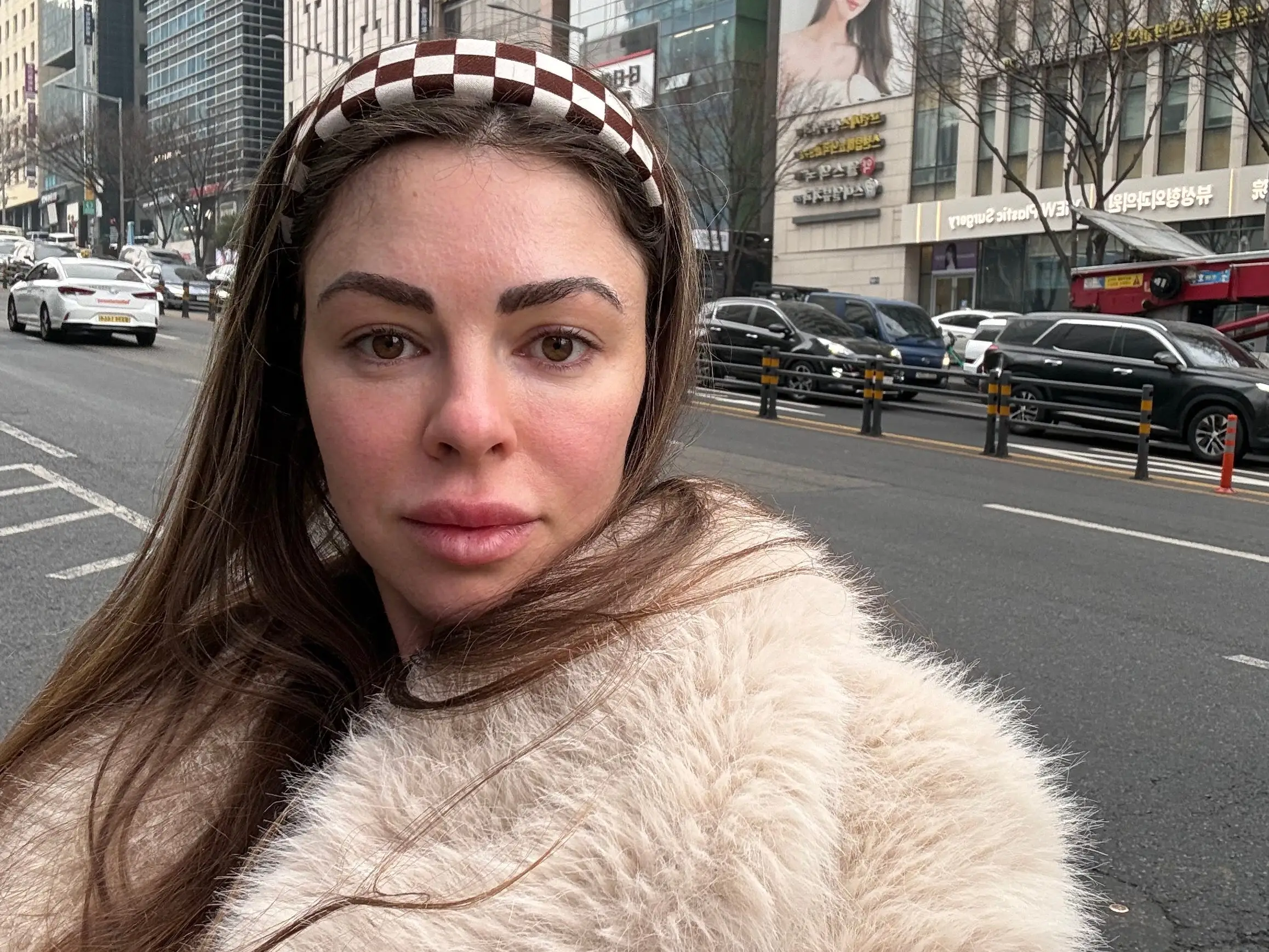 A woman standing in front of tall buildings.