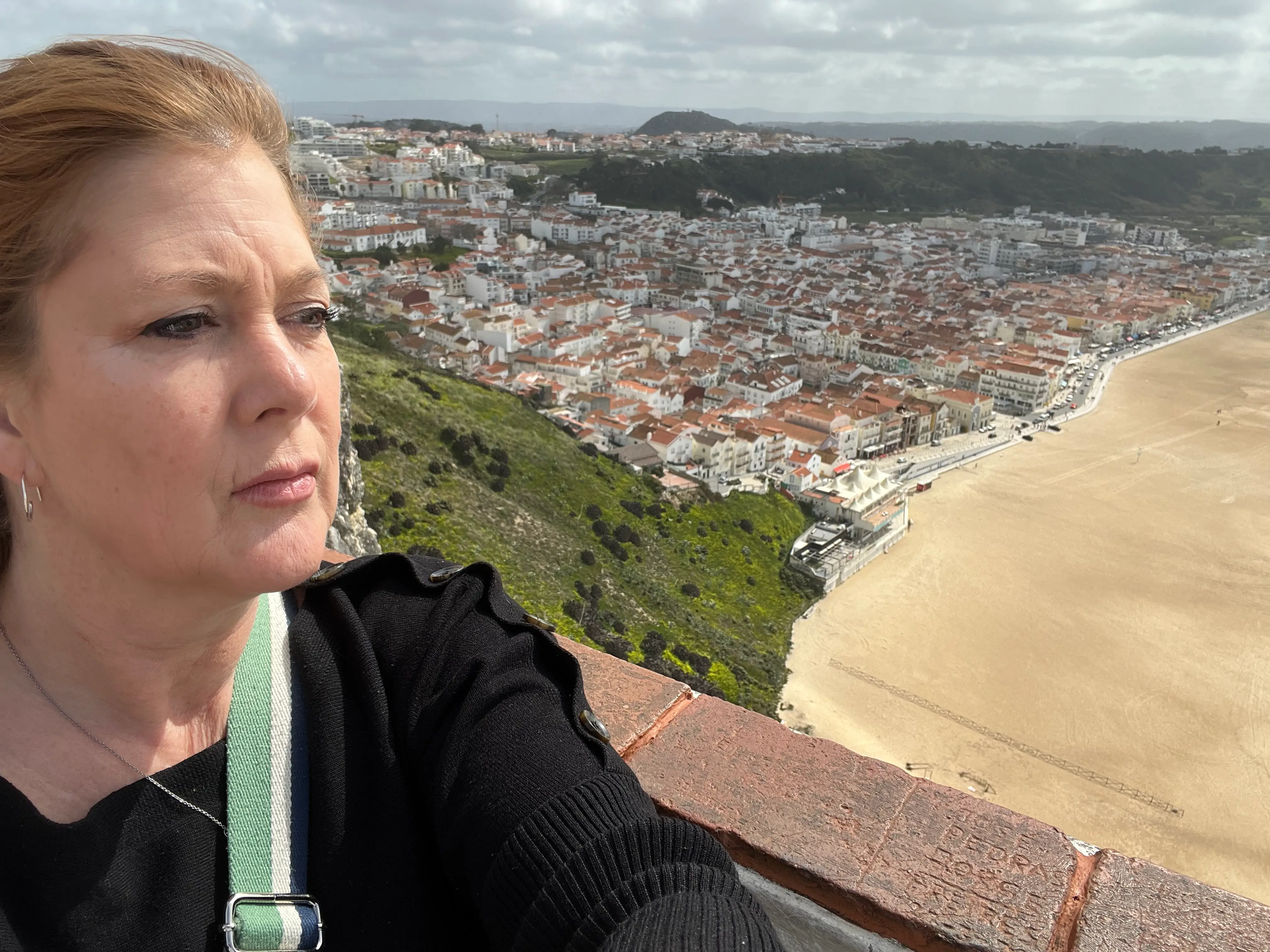 Portrait of a woman with the beach in the distance.