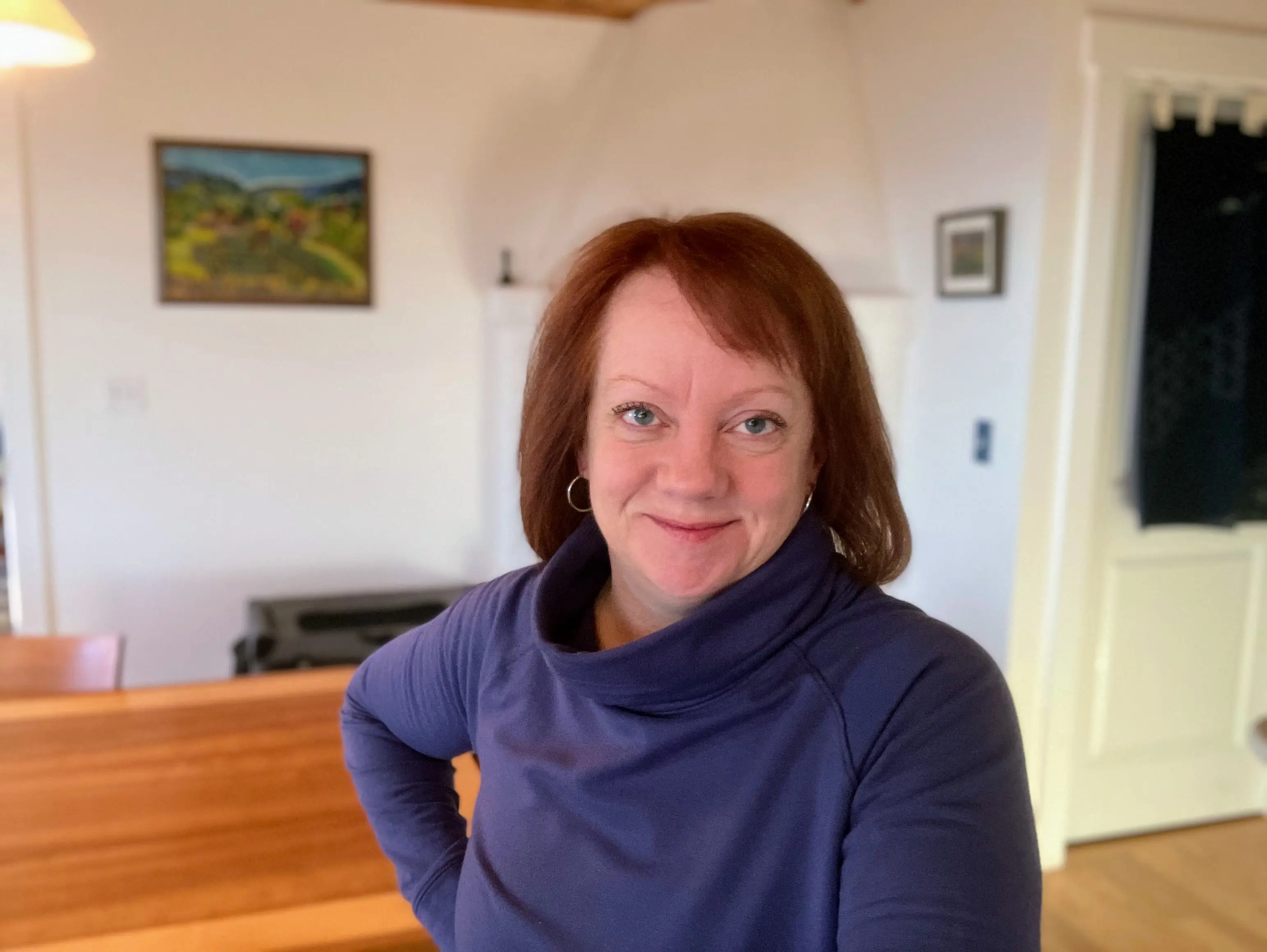 Woman smiling wearing turtleneck in room