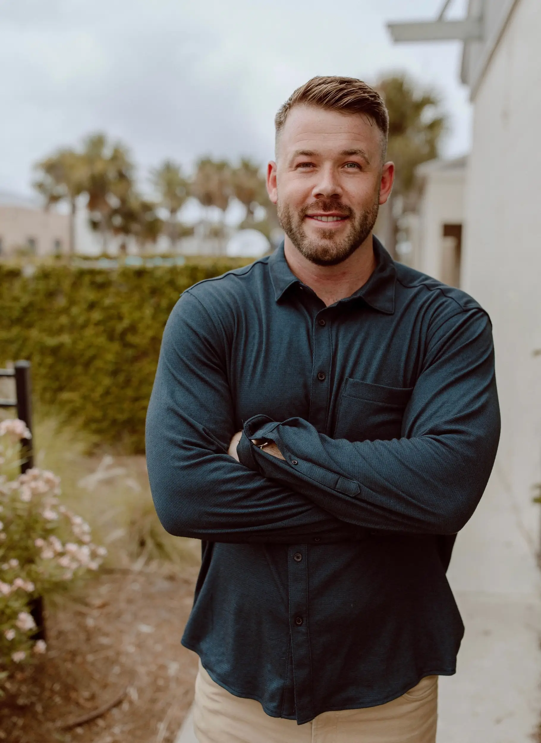 A professional headshot of a man outdoors.