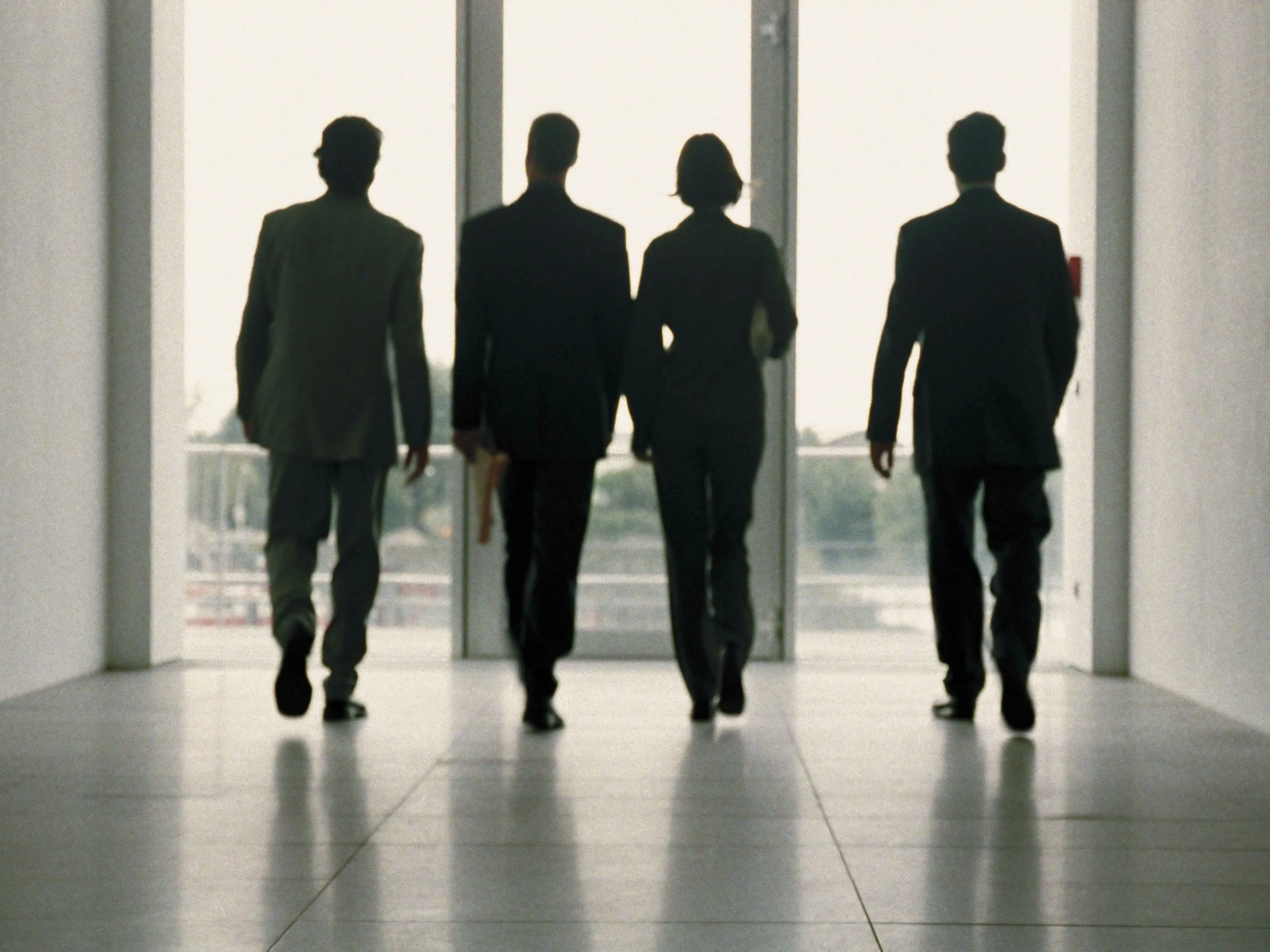 People in professinal outfits walking from behind