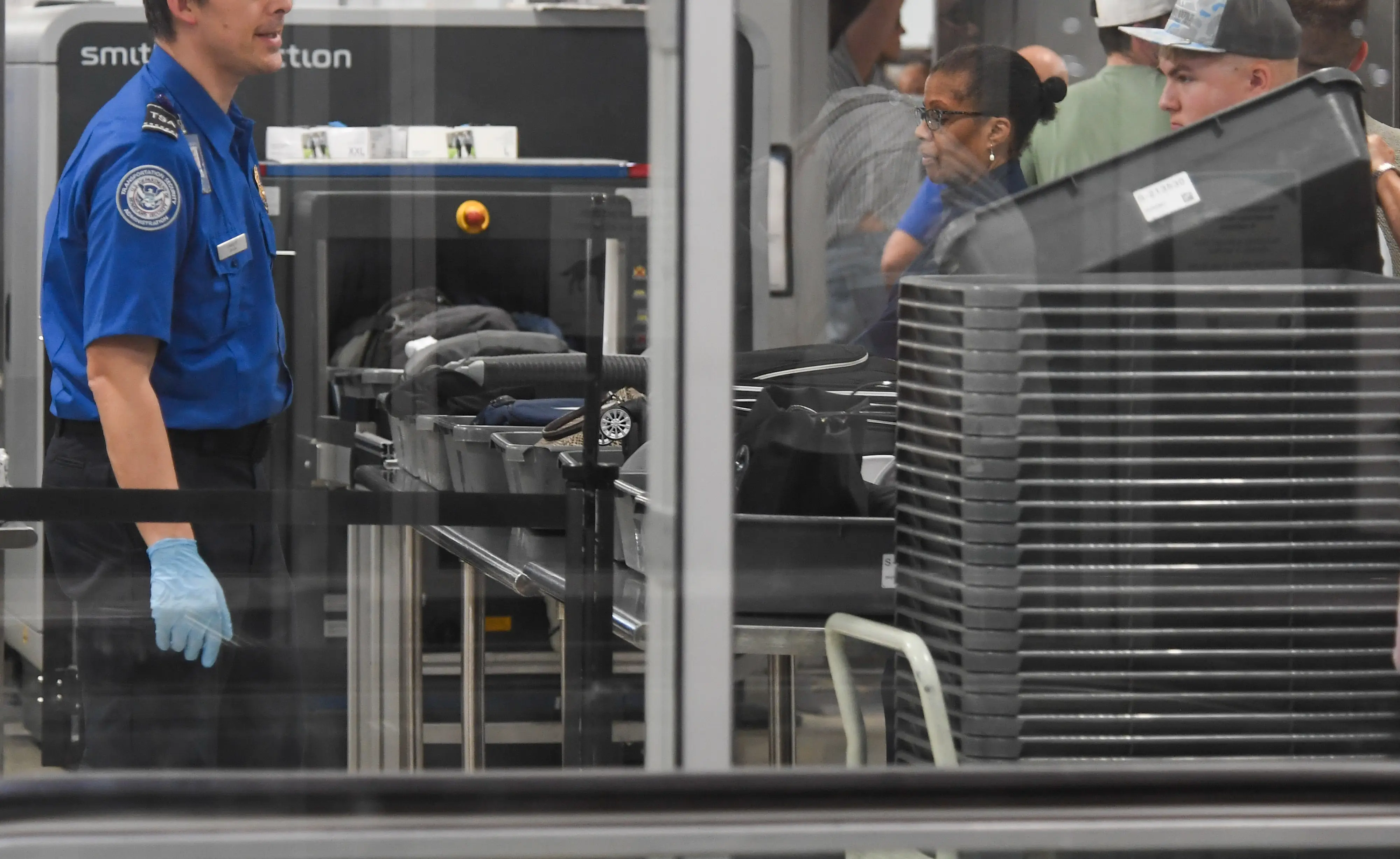 A Transportation Security Administration (TSA) agent assists travelers at a security checkpoint at Philadelphia International Airport (PHL) in Philadelphia, Pennsylvania, US, on Monday, March 23, 2026