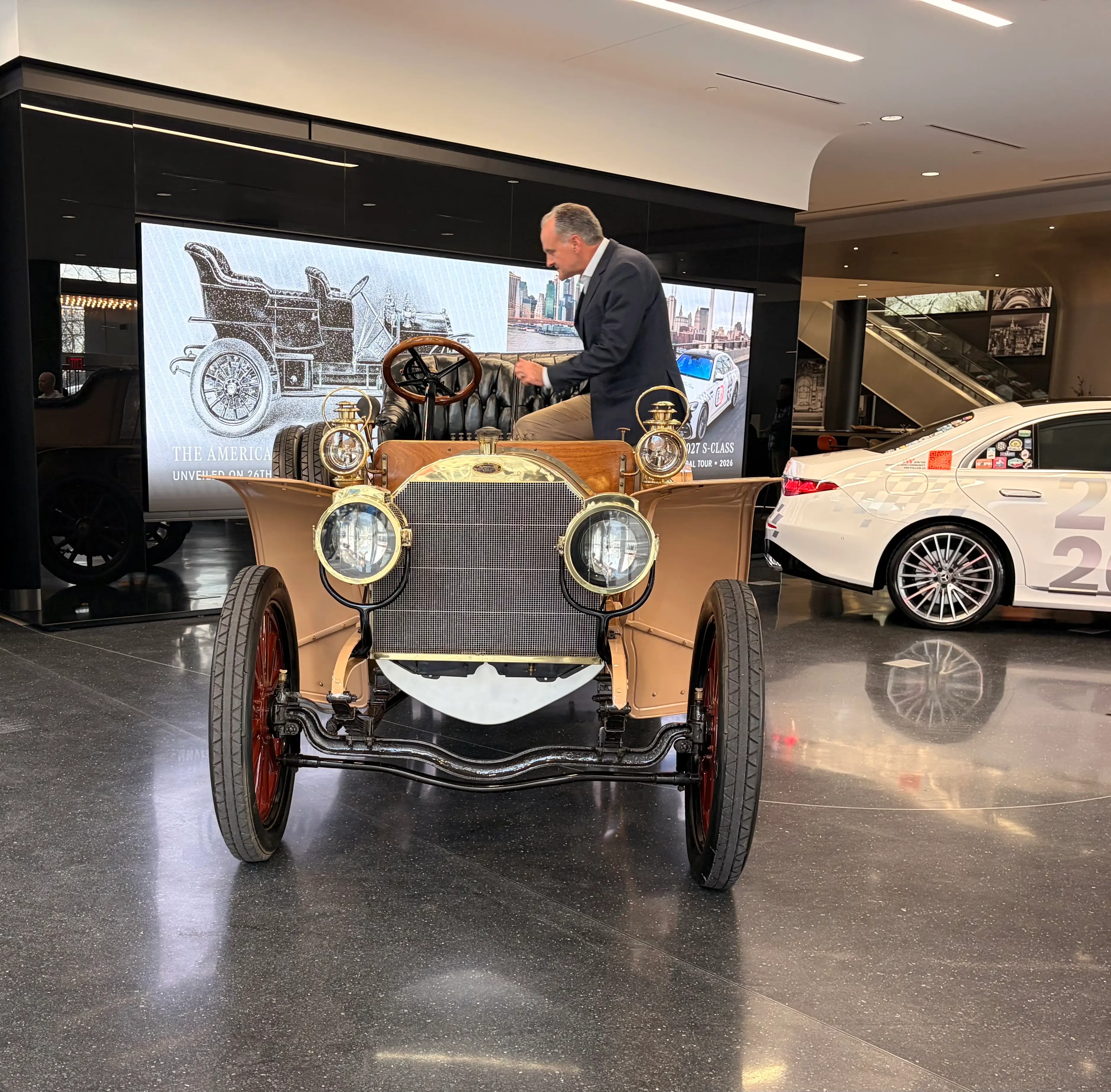 Jason Hoff, dressed in a suit jacket and khakis, steps into the classic Mercedes vehicle.