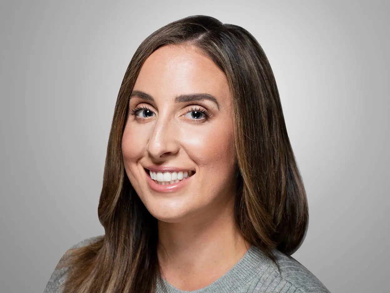 head shot of a woman in a gray outfit with a gray background