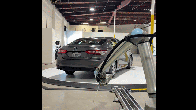 A robotic arm scans a car.