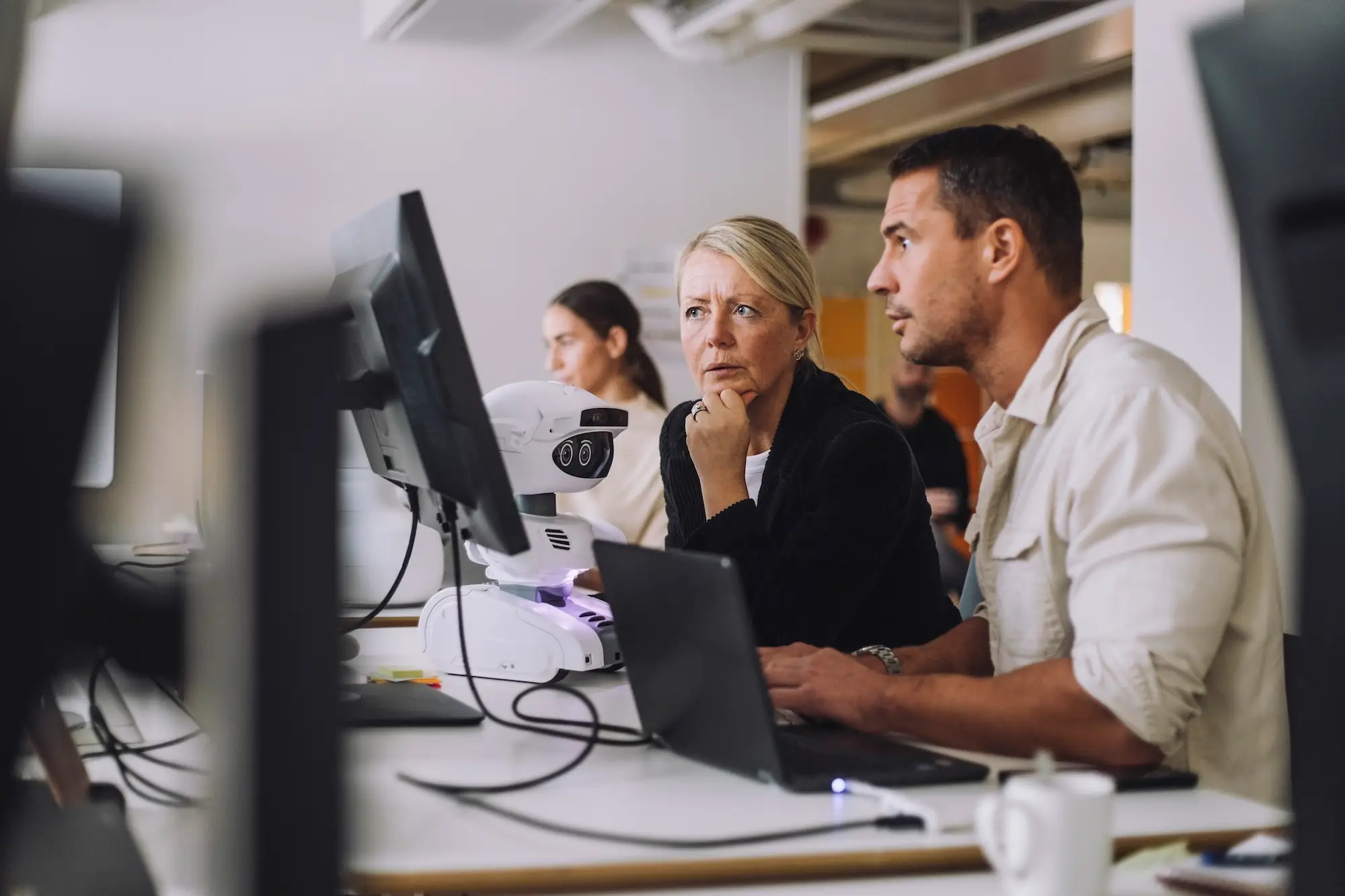 Two workers look at a computer screen in an office