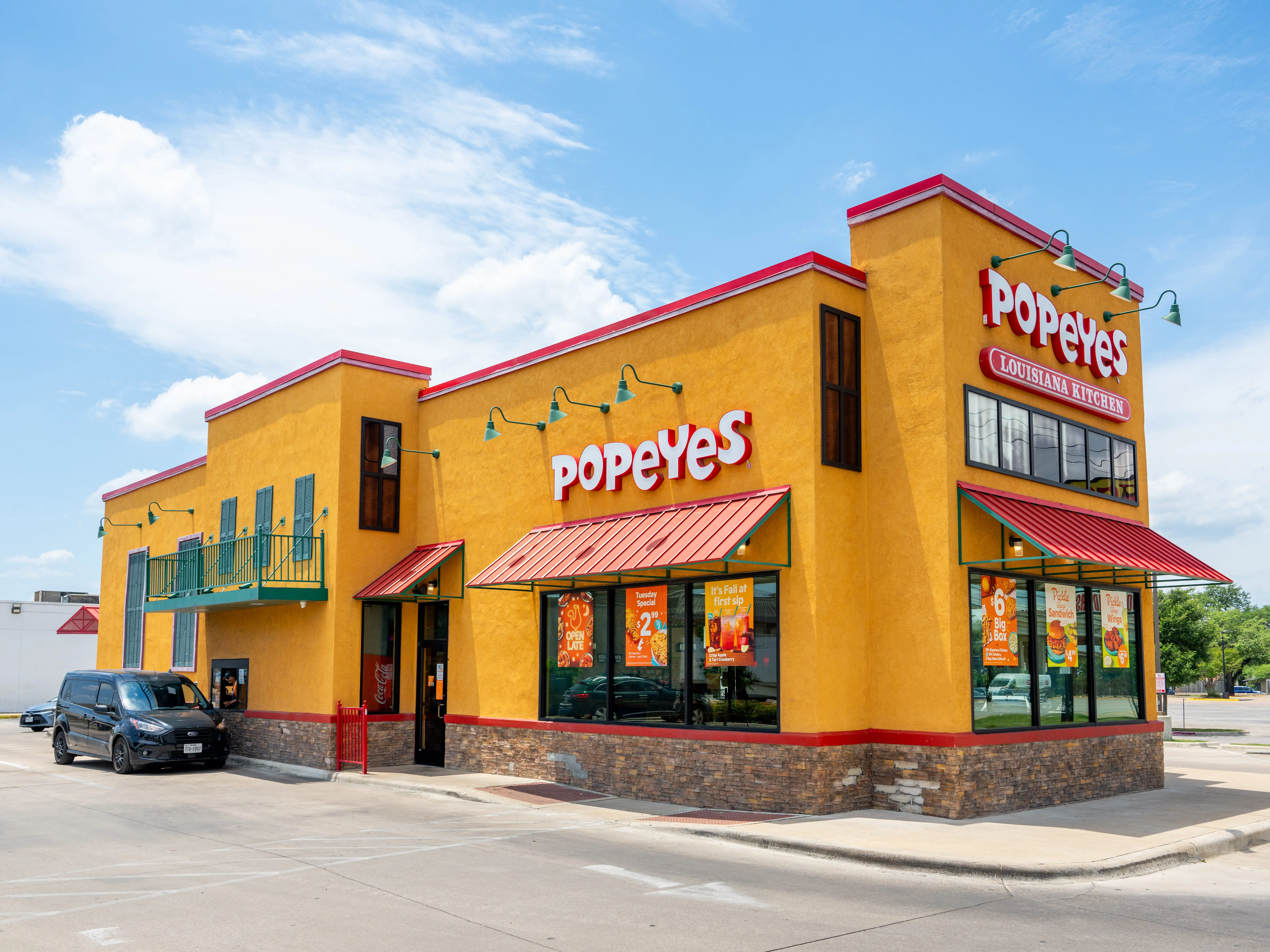 Popeyes restaurant with a car in the drive through in Austin, Texas.