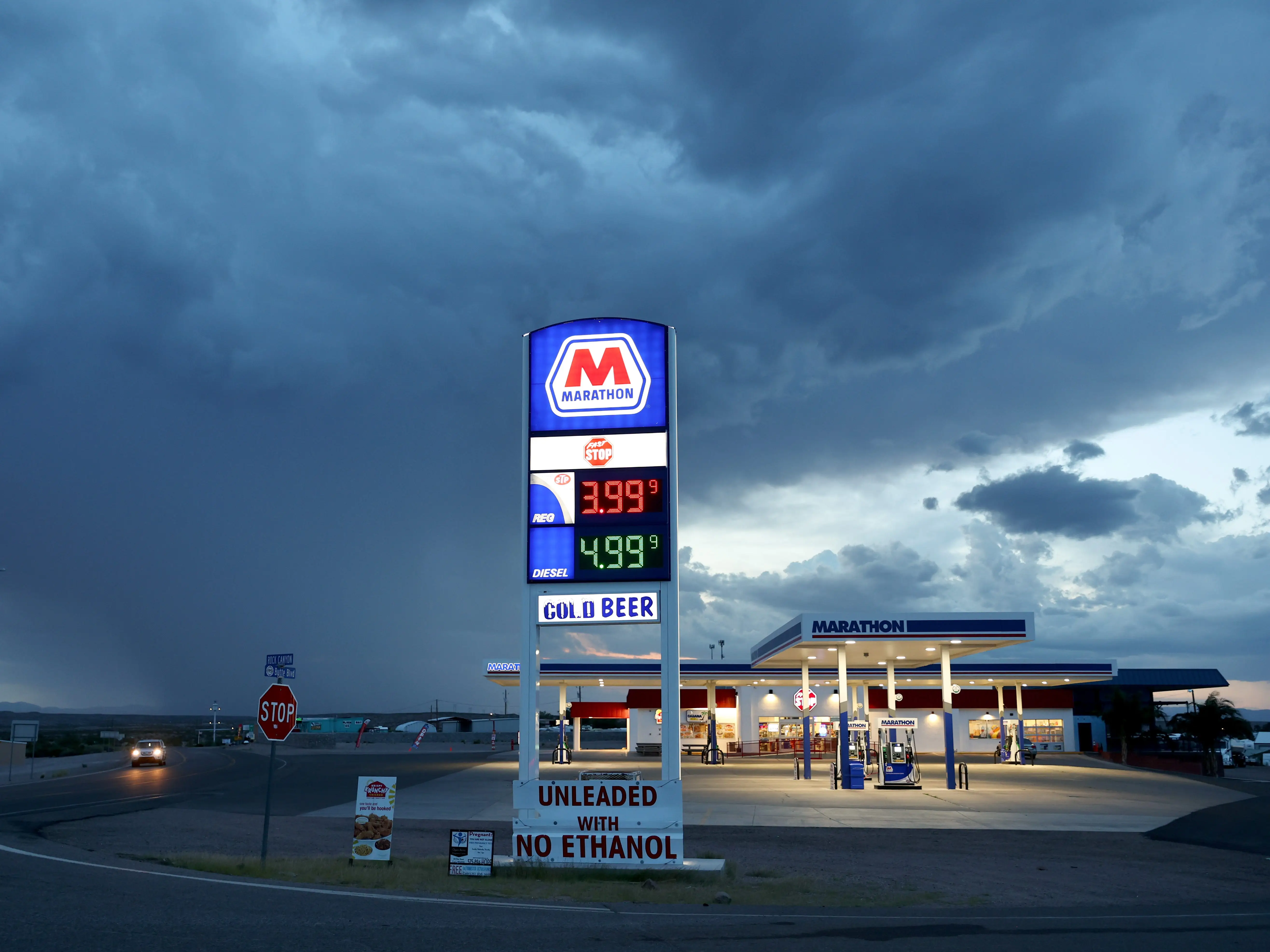 Gas prices are displayed at a gas station near the drought-stricken Elephant Butte Reservoir, as monsoon rain falls in the distance, on August 16, 2022 near Truth or Consequences, New Mexico.